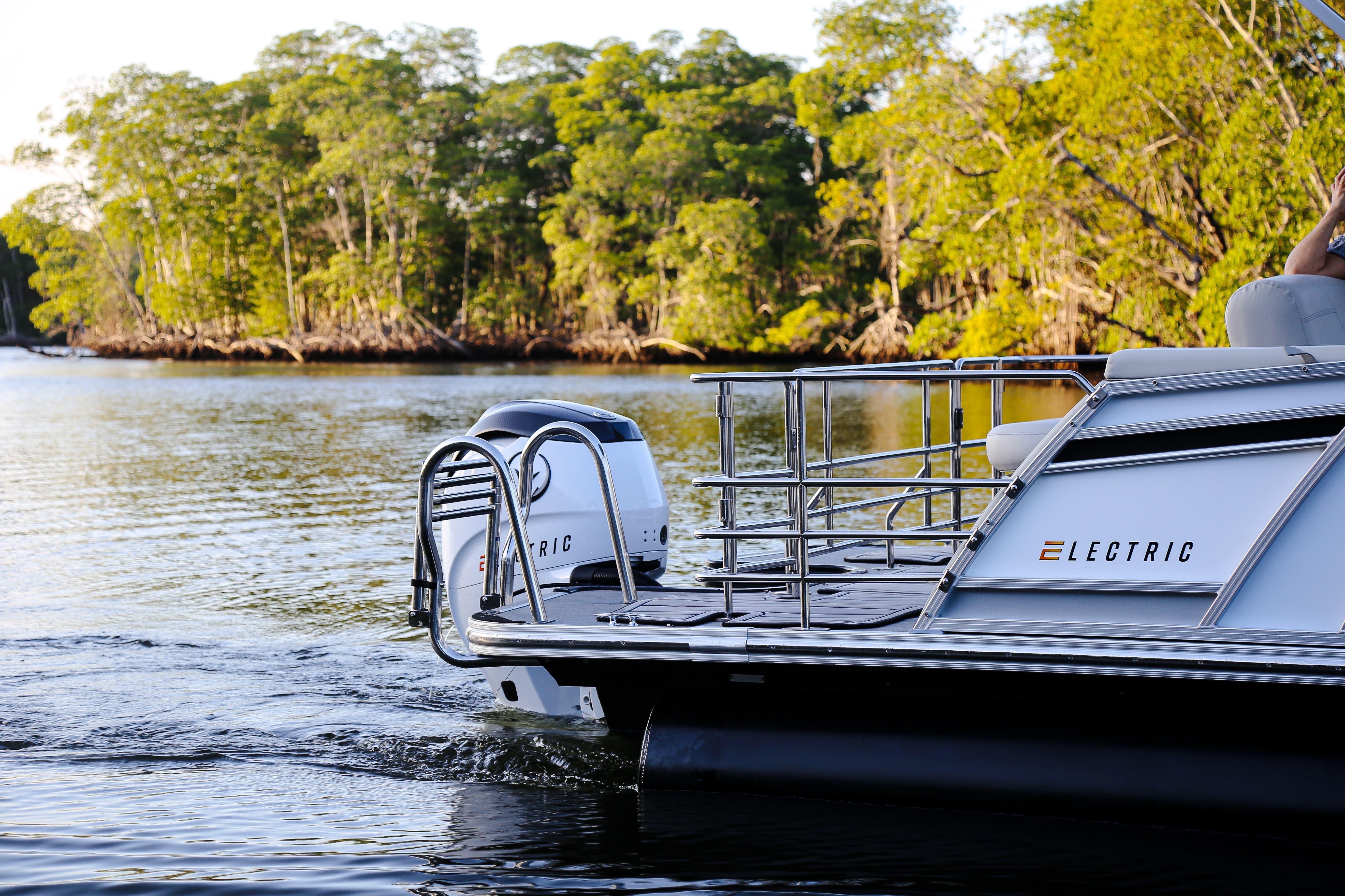 Electric Vision Marine Technologies V24 boat cruising on a serene river, surrounded by lush greenery.