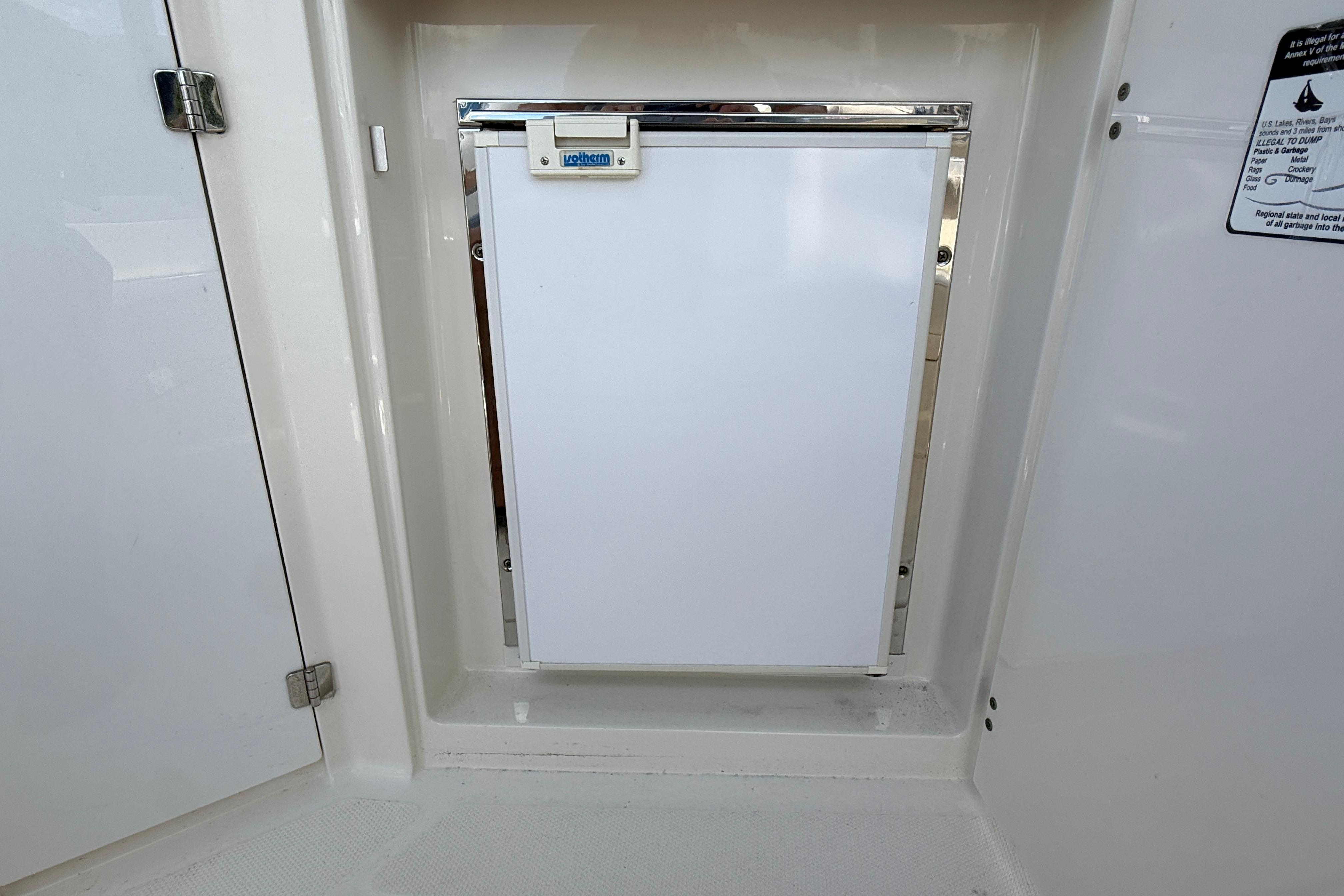 White refrigerator on a 2011 Monterey 320 Sport Yacht, integrated into the cabin interior.