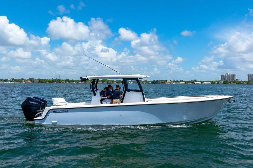 2027 Reef Runner 340 boat cruising on a sunny day with passengers onboard.