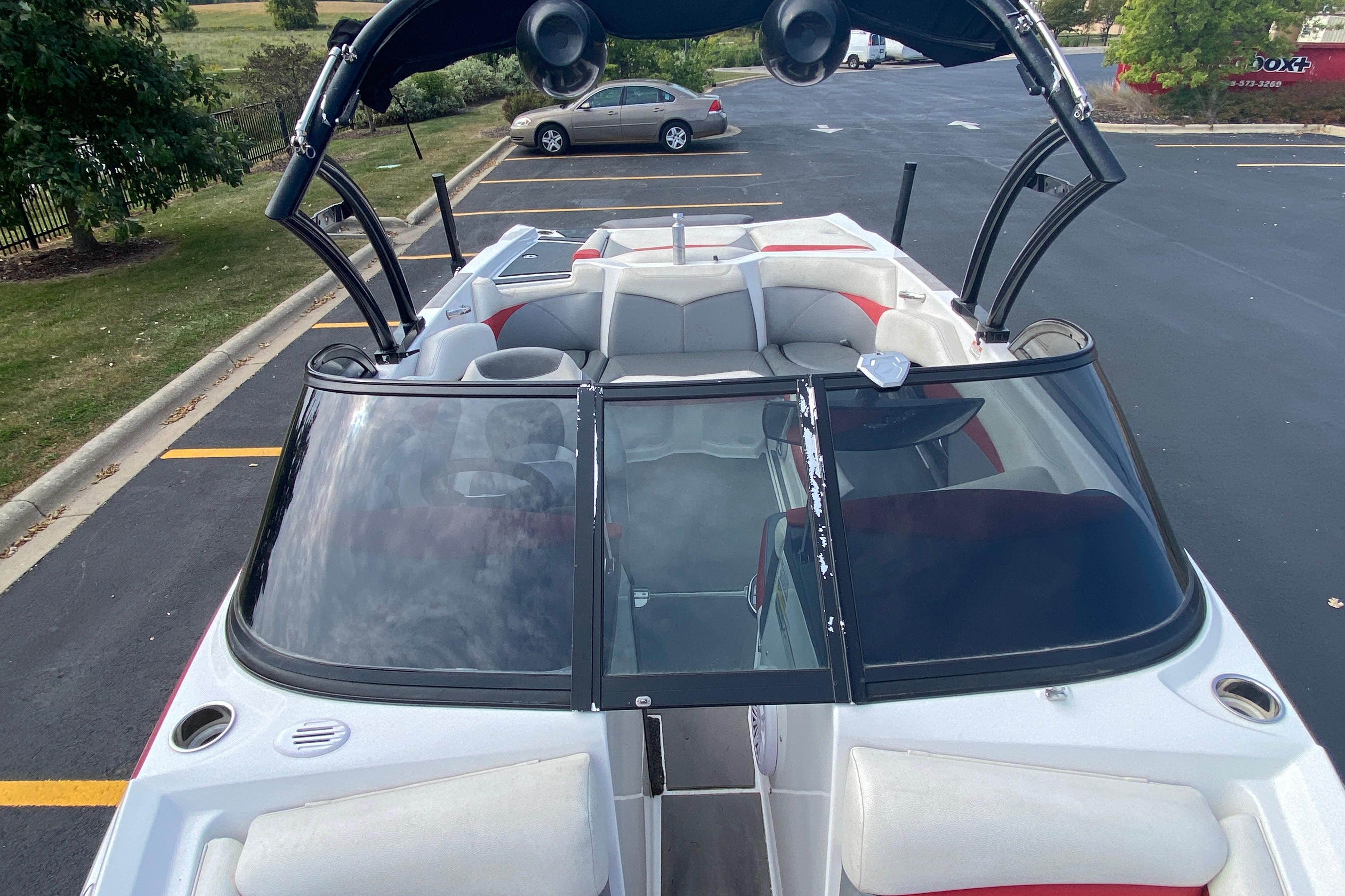 2014 Tigé R20 boat with open seating, parked in a lot.
