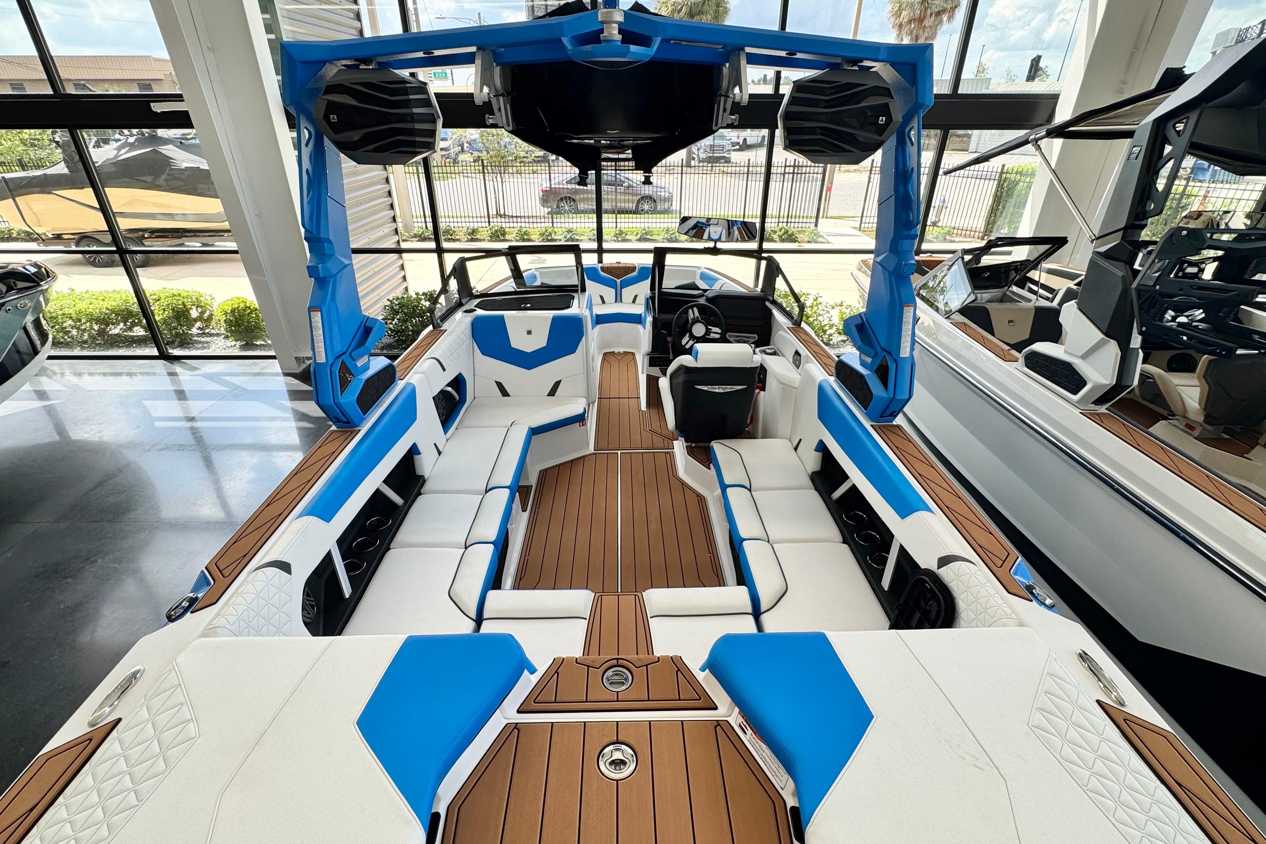 2026 Nautique Super Air Nautique GS22 interior with blue and white seating, wooden flooring.