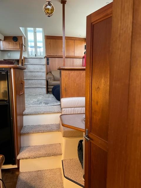 Interior of a 1996 Carver 370 yacht with wooden cabinetry and carpeted stairs.