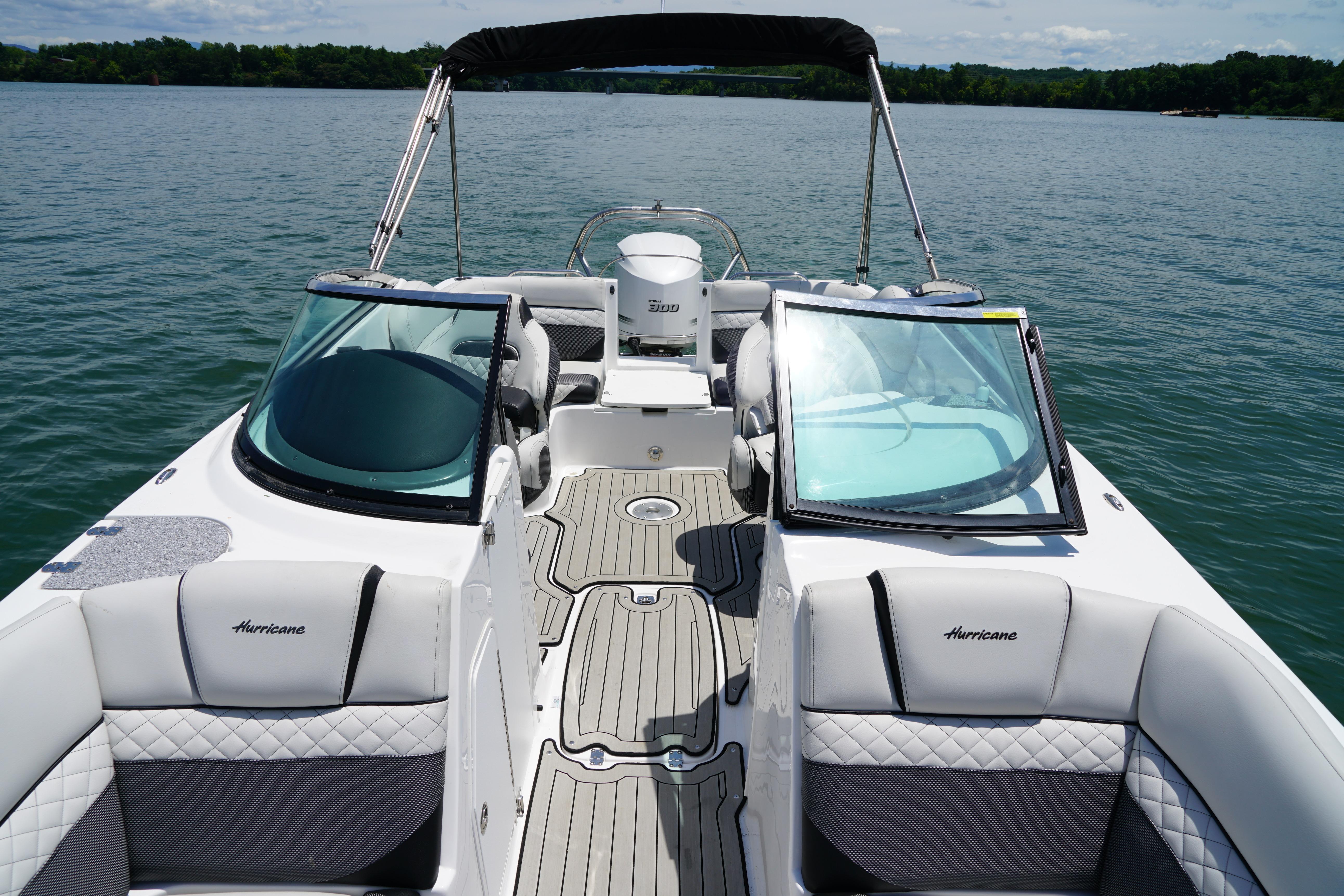 2020 Hurricane SunDeck 2486 OB boat with sleek design on a serene lake.