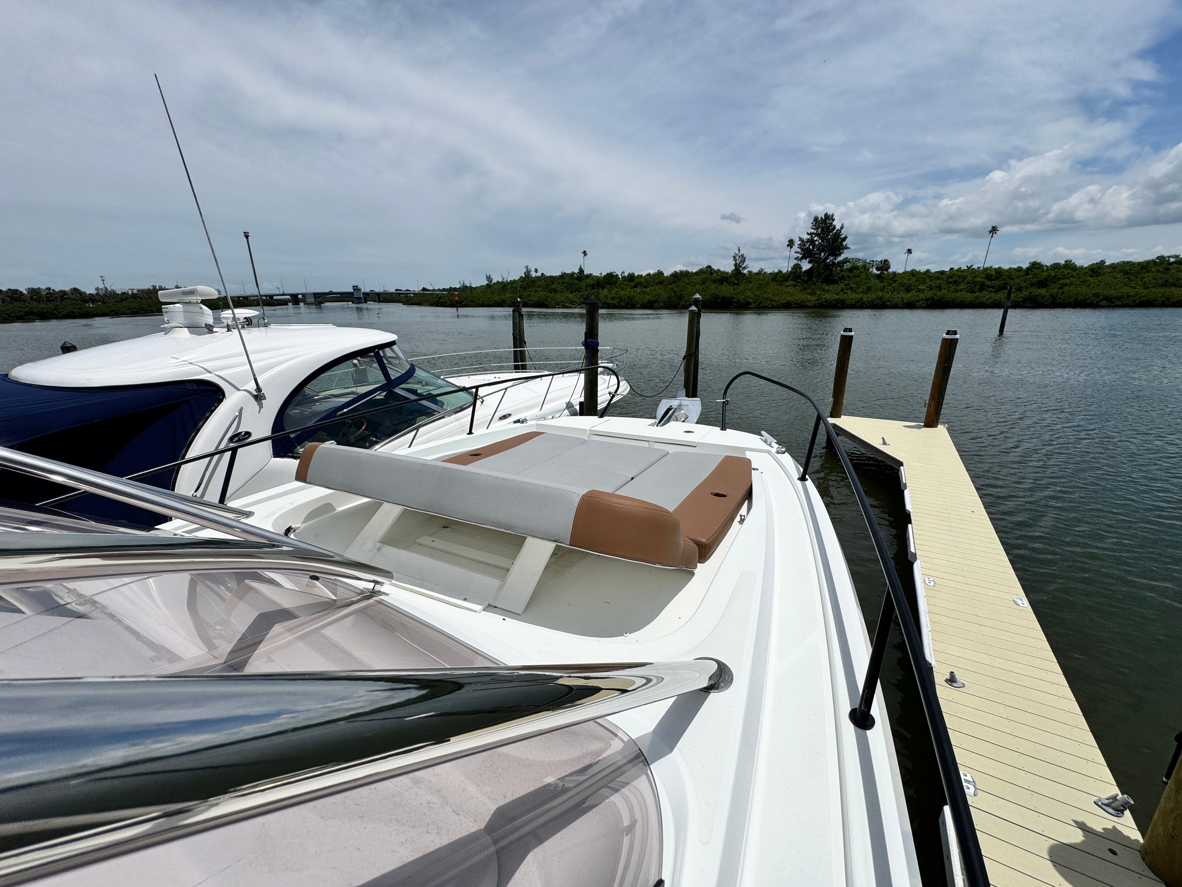 2022 Beneteau Flyer 9 SUNdeck moored at a dock, under a partly cloudy sky.