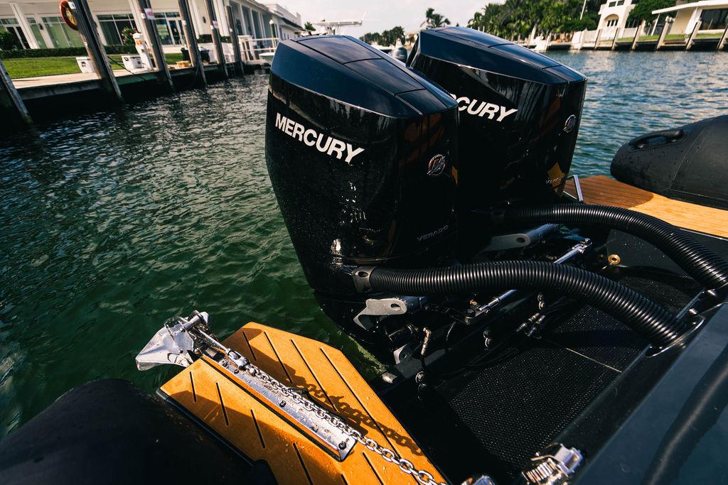 Twin Mercury outboard engines on a 2025 Onda Magna boat, docked by the water.