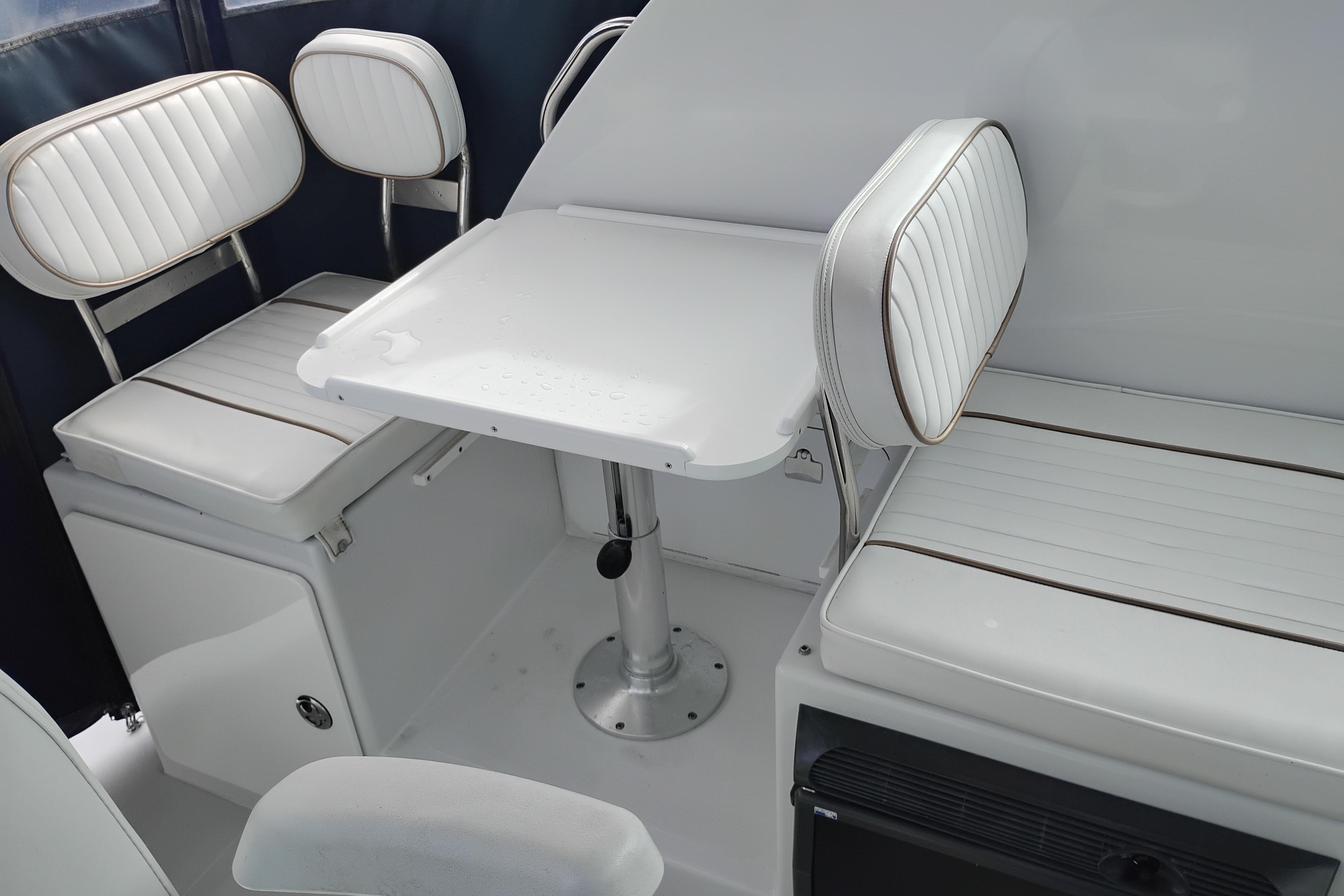 2007 Glacier Bay 2685 Coastal Runner interior with white seating and table.