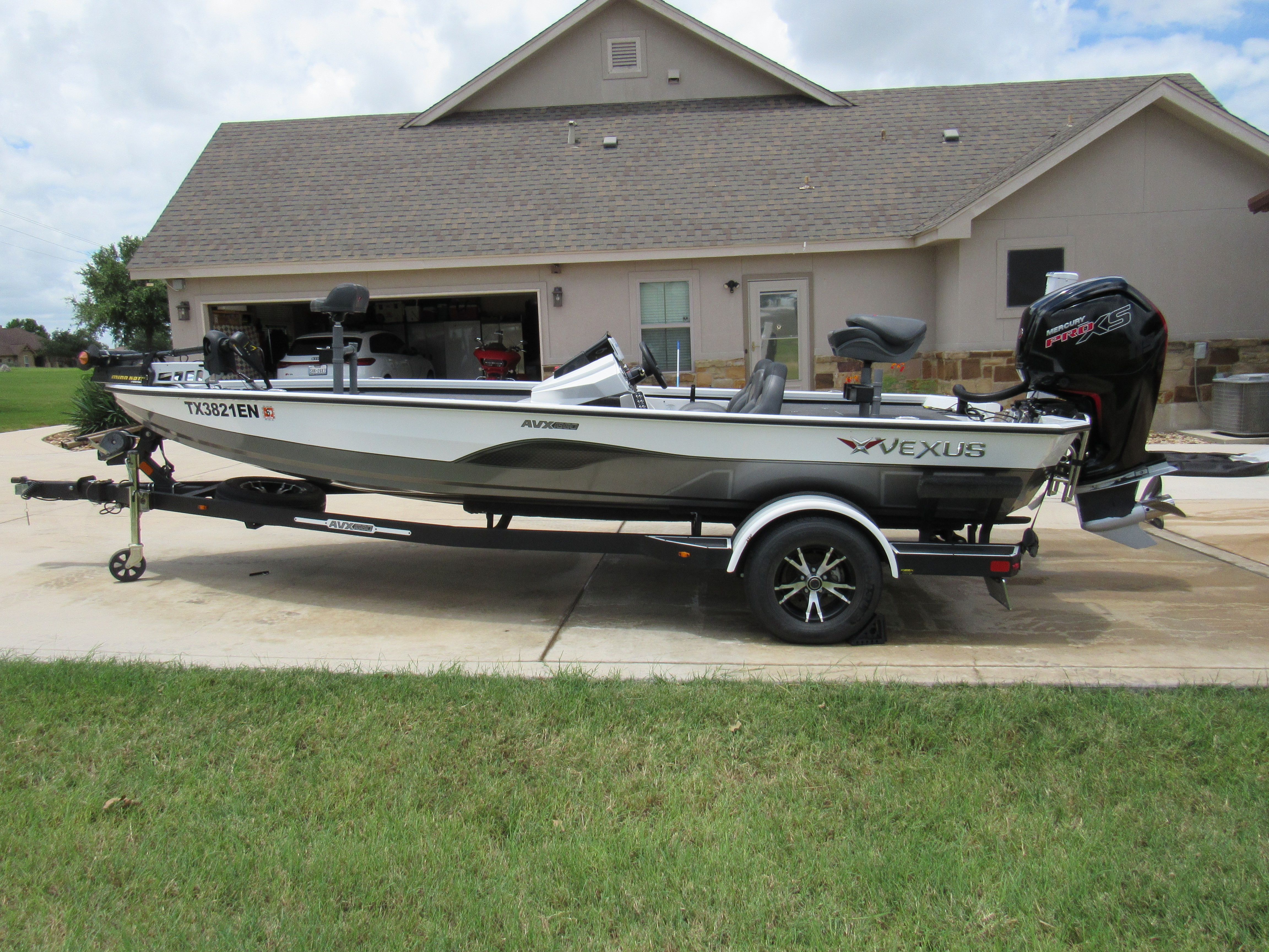 A 2019 Vexus AVX 1880 boat on a trailer in front of a house.