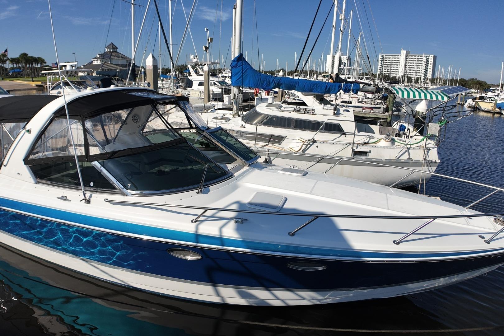 2007 Formula 330 Sun Sport boat docked at a marina under clear blue skies.
