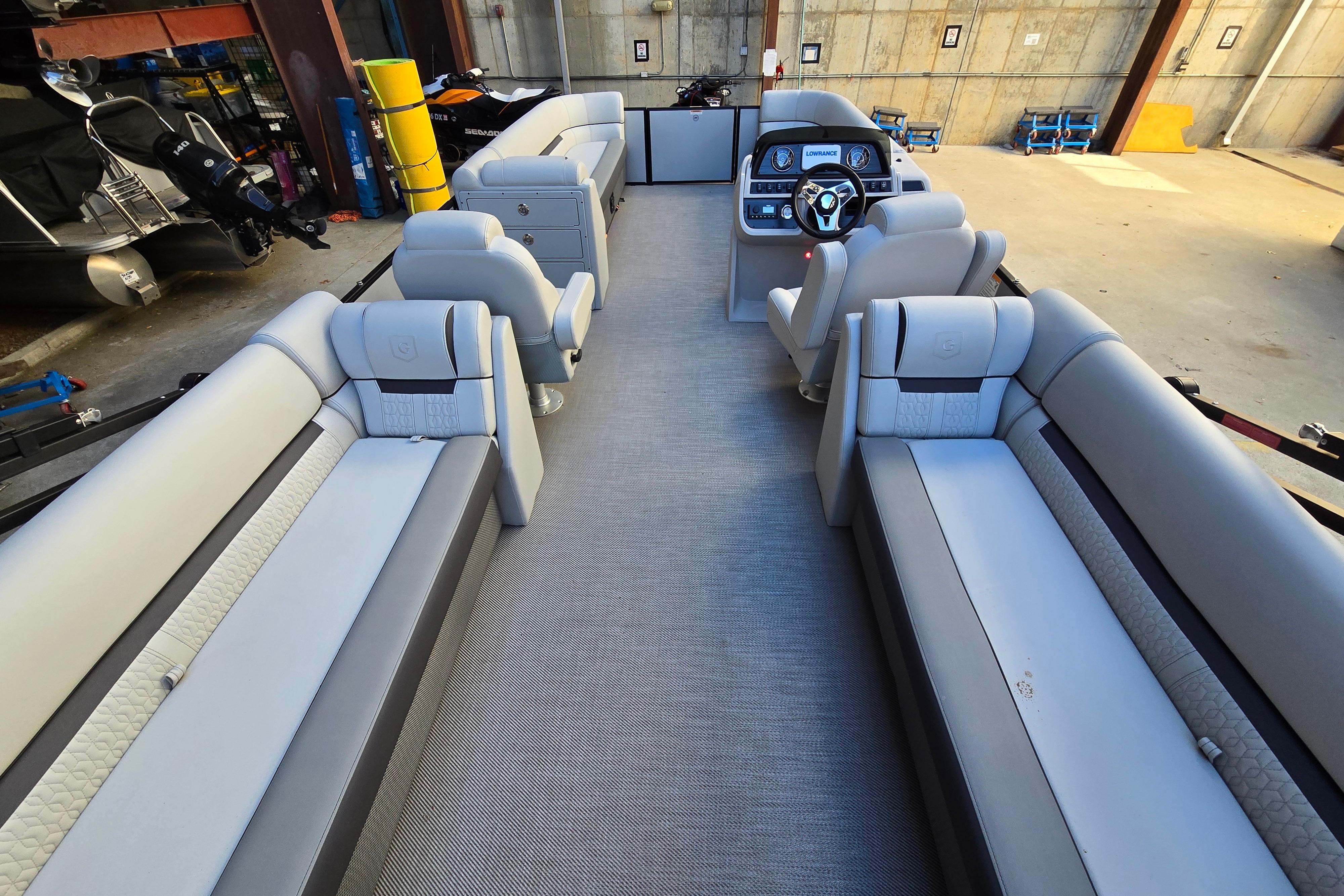 Interior of 2024 Godfrey Sweetwater 2486 SB pontoon boat with luxurious seating and helm.