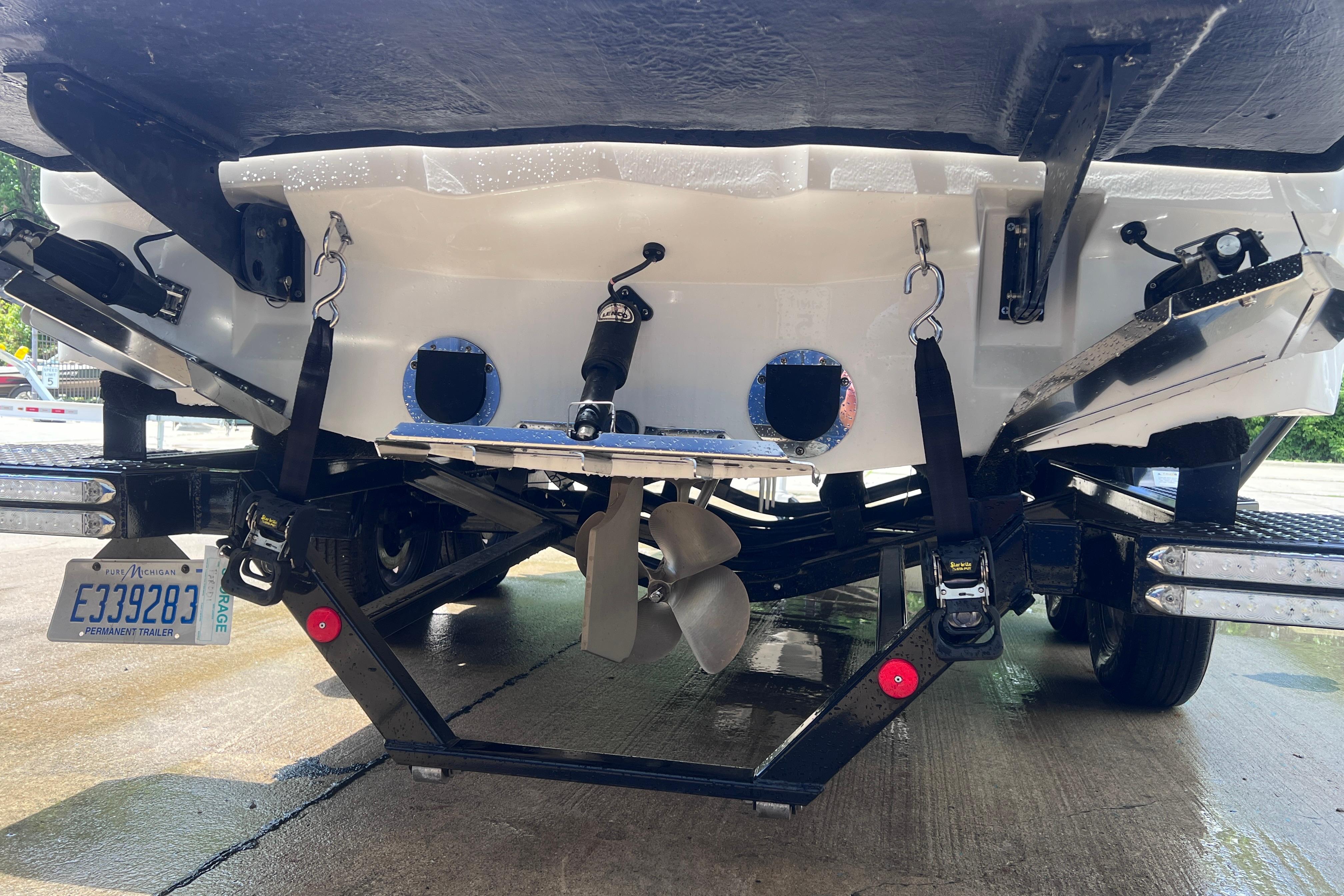 Rear view of a 2021 MasterCraft XT23 boat on a trailer, showing propeller and license plate.