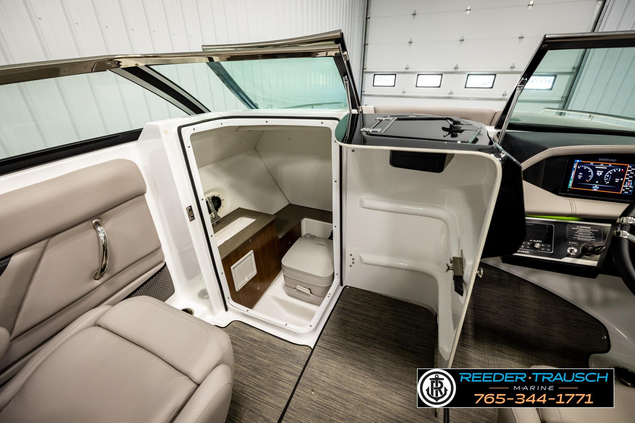 2024 FOURWINNS HD5 Surf boat interior with open cabin door and seating area.