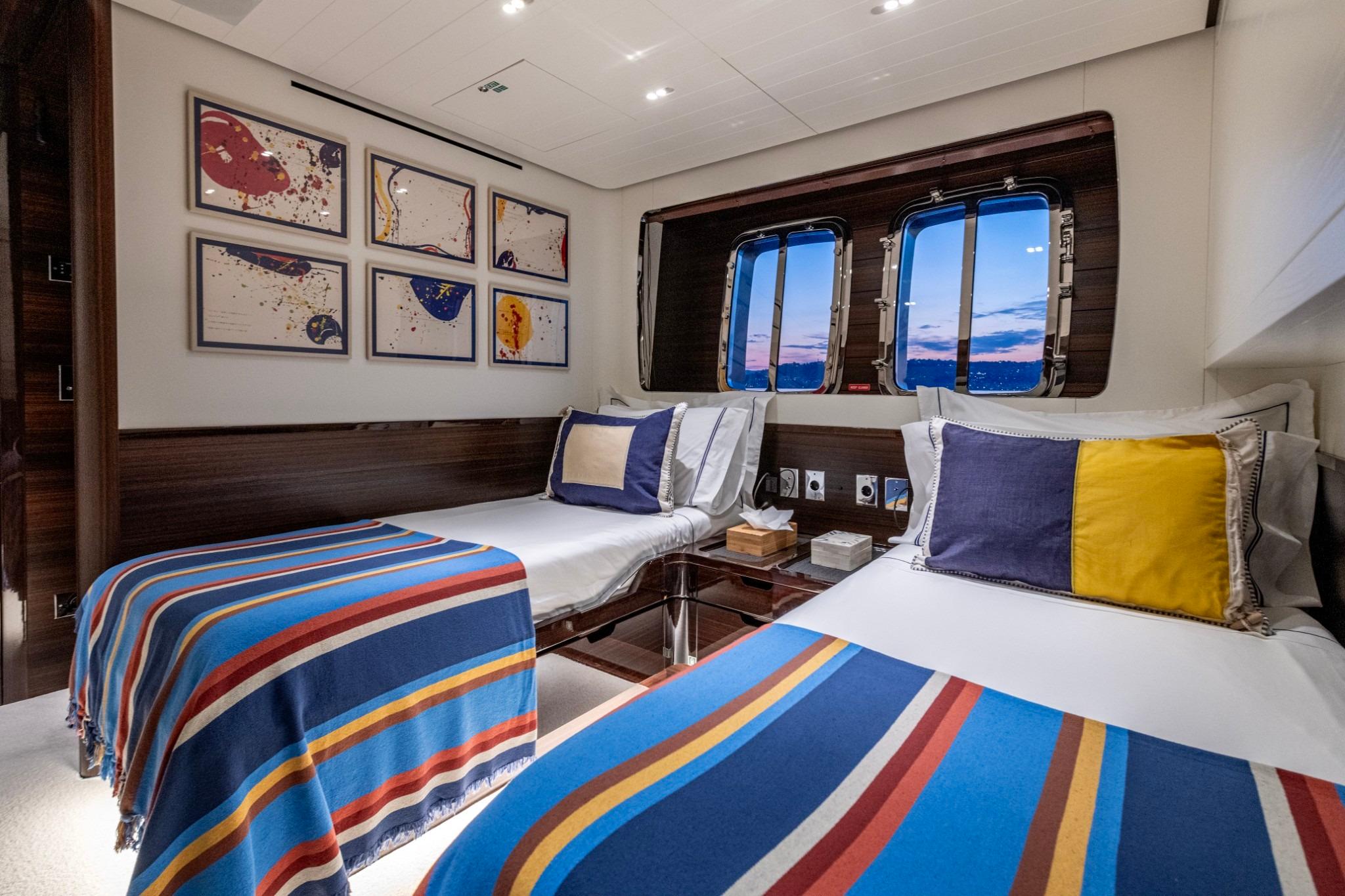 Luxurious 2016 Sanlorenzo SL96 yacht cabin with twin beds, colorful decor, and ocean view.