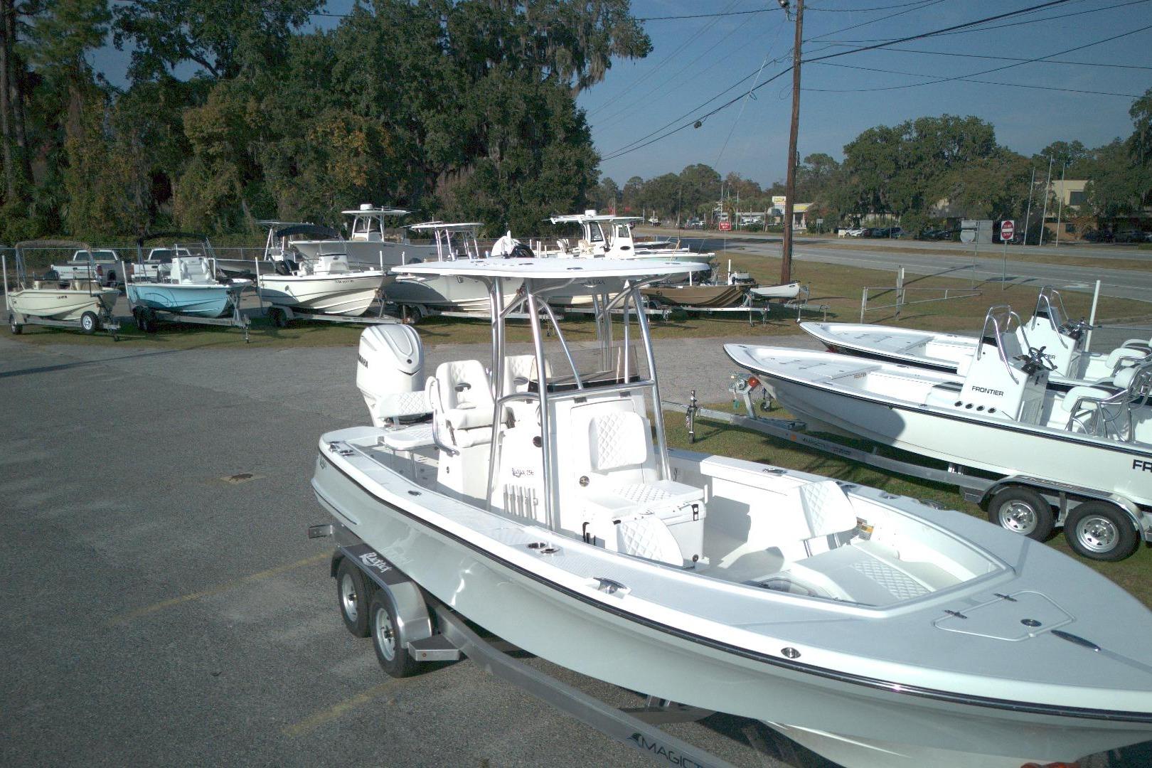 2026 BlackJack 256 Coastal boat on trailer in dealership lot, surrounded by other boats.