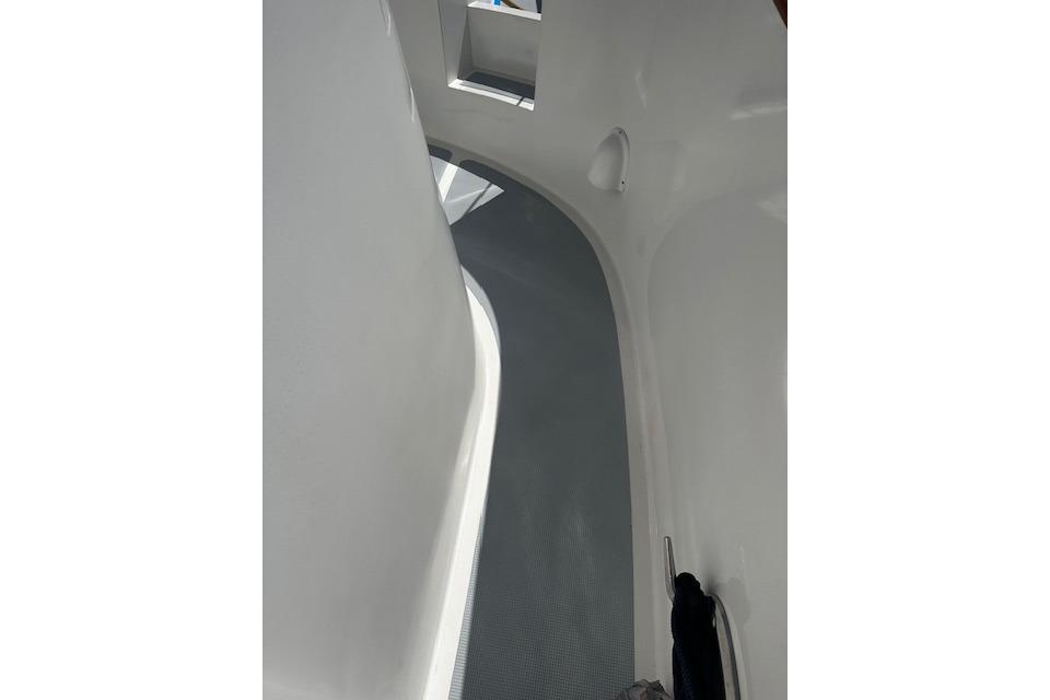 Narrow walkway on a 1998 Nordhavn 46 yacht, featuring sleek white surfaces.