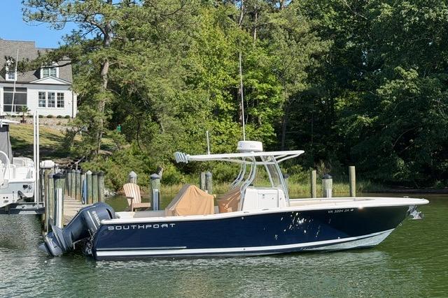 2014 Southport 29 FE boat docked by a lush, green shoreline.