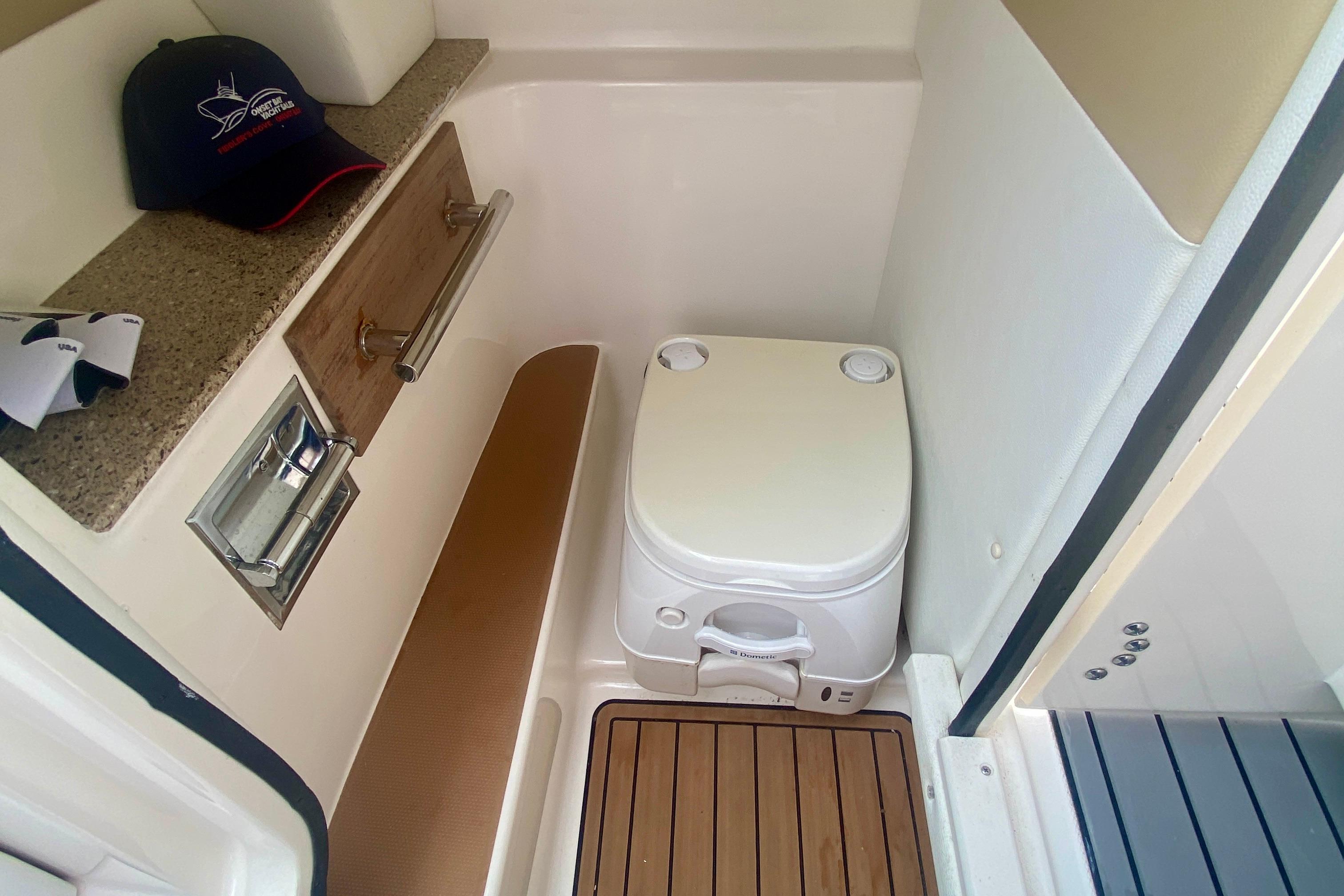 2015 Sea Ray 250 SLX boat interior with portable toilet and storage area.