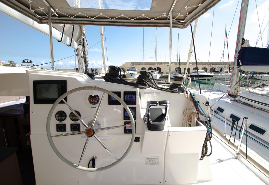 Helm of 2019 Fountaine Pajot Lucia 40 catamaran in marina setting.