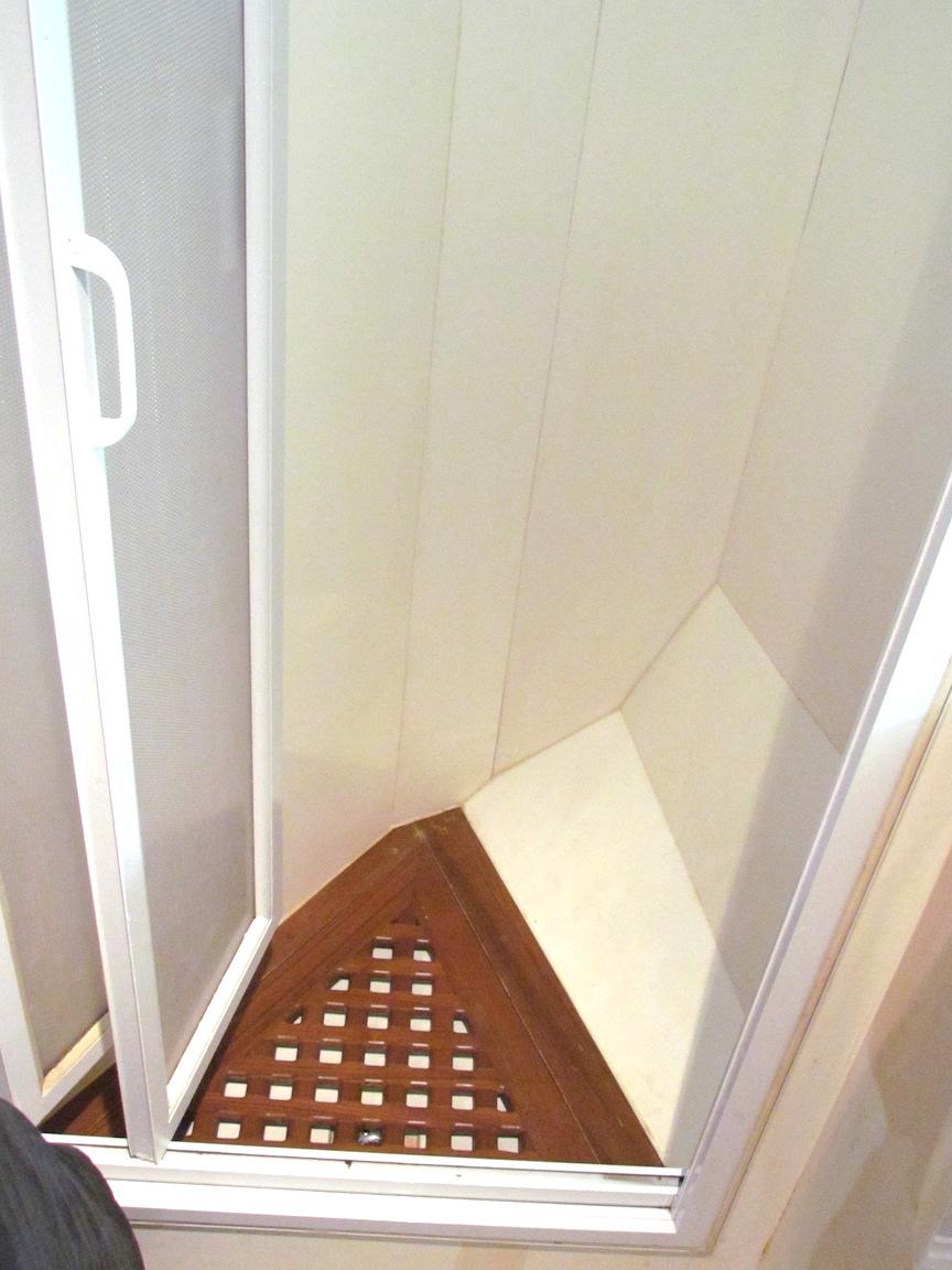 Small shower with wooden floor in a 1997 Hyatt 55 model.