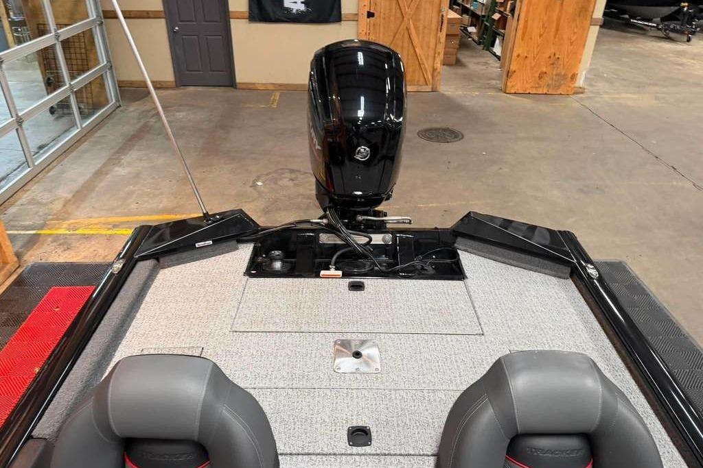 2024 Tracker Pro Team 175 boat interior with motor, in a showroom setting.