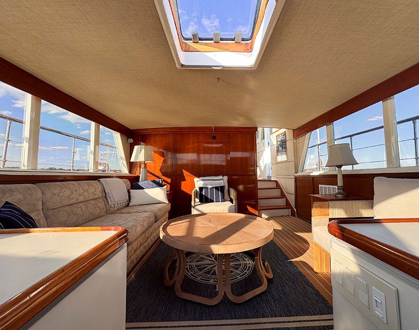 Interior of a 1961 Burger 63 yacht with elegant furnishings and large windows.