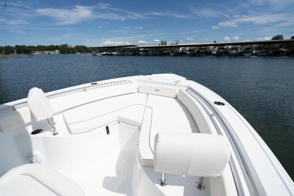 2024 Sea Hunt Ultra 234 boat with white seating on a calm lake.