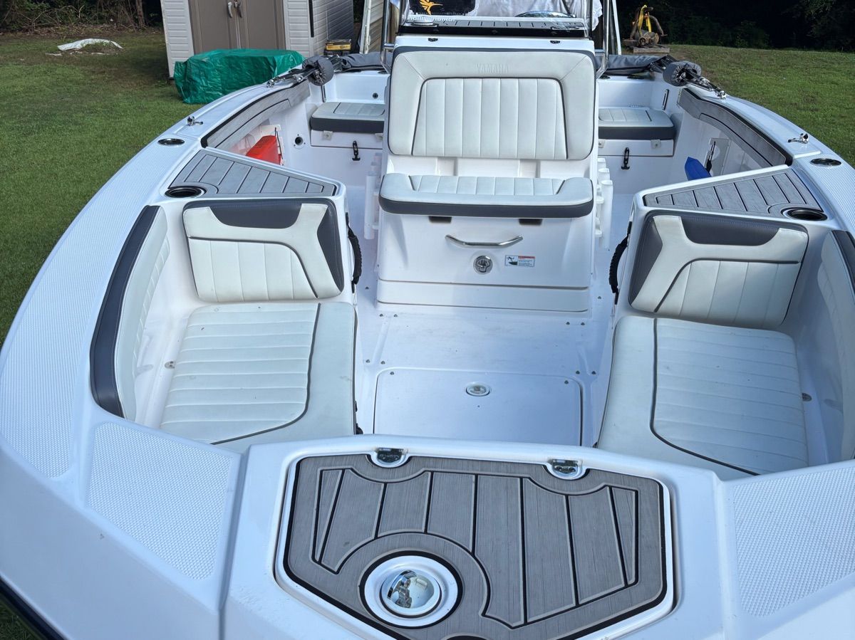 Interior of a 2020 Yamaha 210 FSH Deluxe boat on grass.