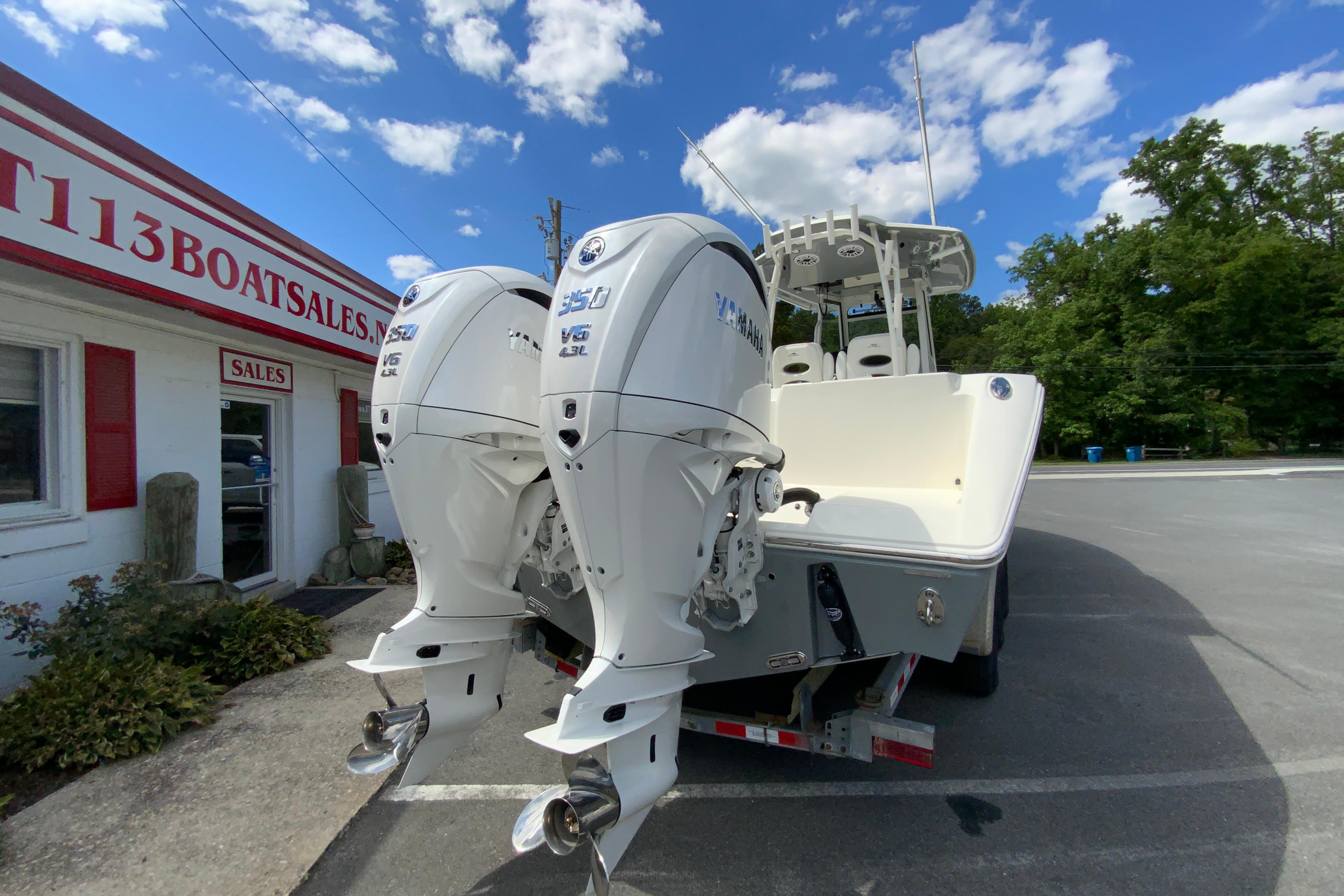 2027 Cobia 320 Center Console boat with twin Yamaha engines at a dealership.