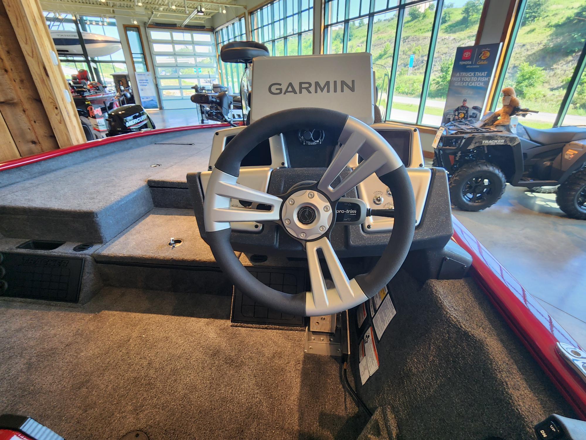 The image shows the steering wheel of a Tracker Savage 215 boat in a showroom.