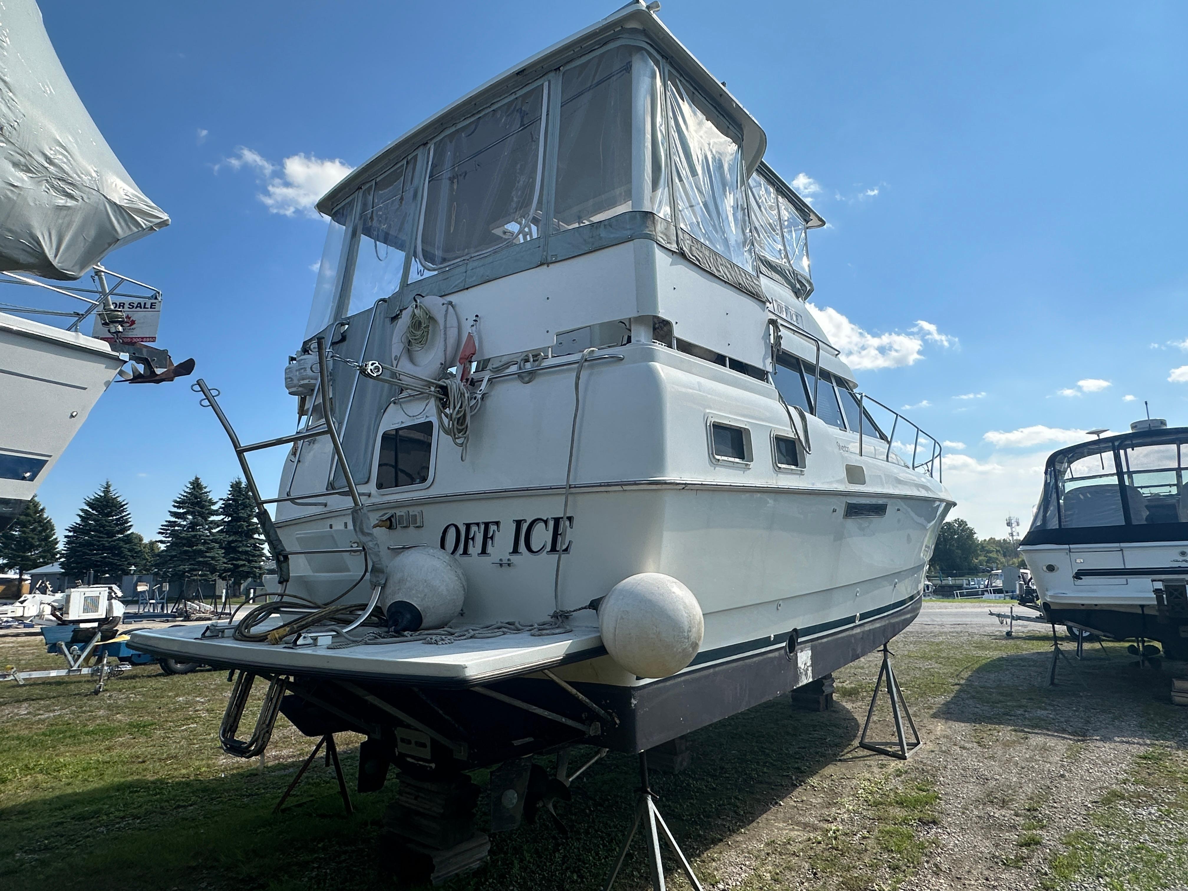 1994 Silverton 34 Aft Cabin Motor Yacht on land, named "Off Ice," under clear blue sky.