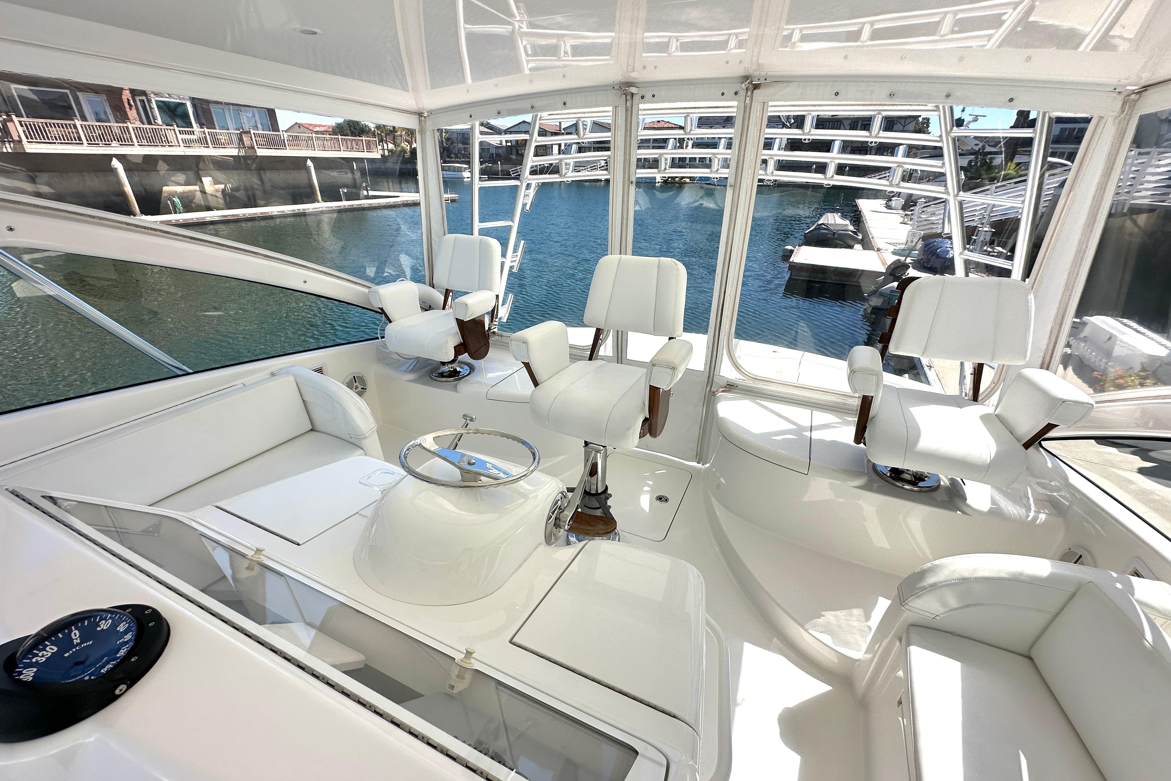 Luxurious interior of a 2012 Viking 42 Open yacht with white seating and panoramic windows.