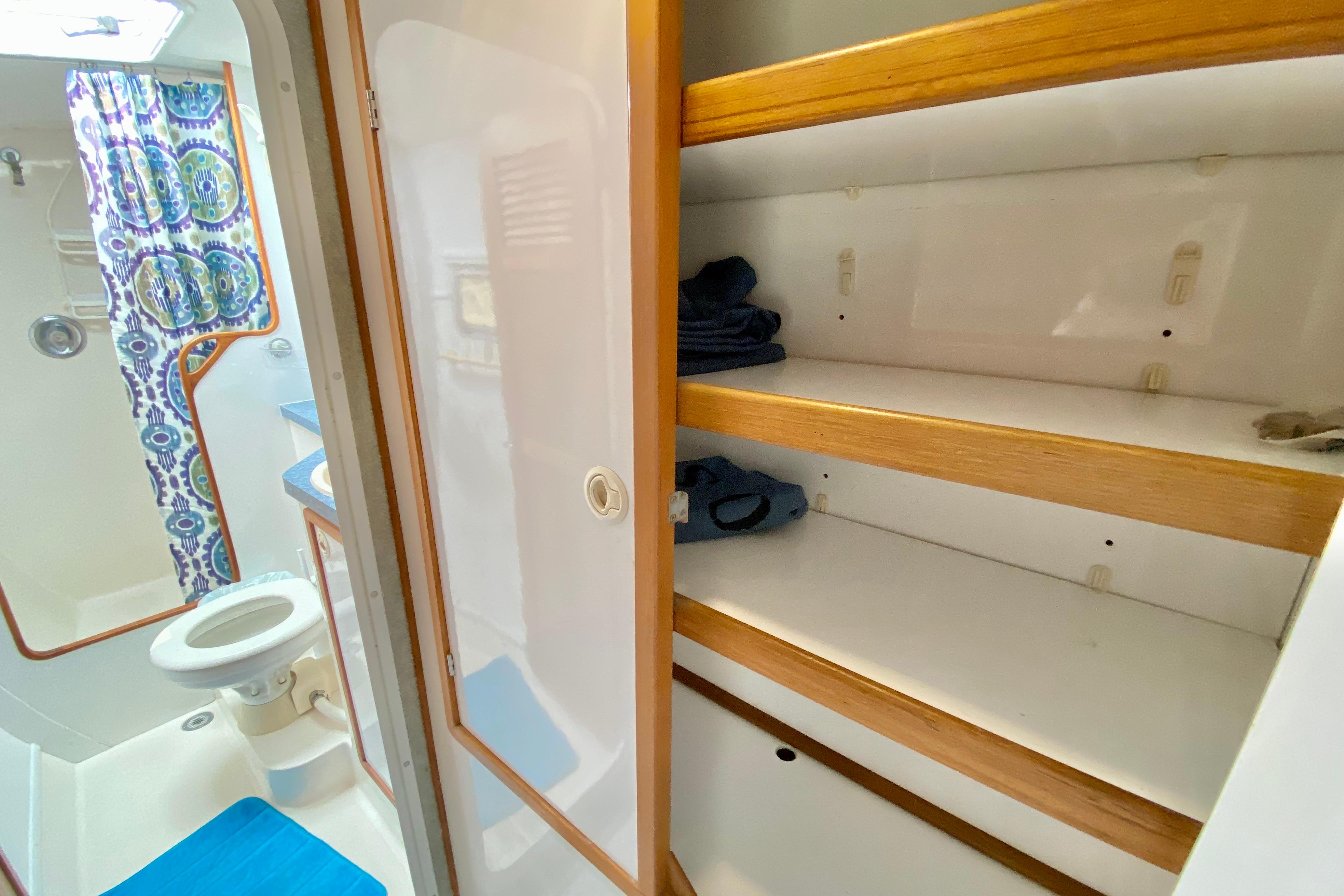 1998 Manta 40 yacht bathroom with storage shelves and colorful shower curtain.