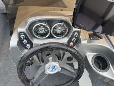 Boat dashboard with steering wheel and instruments.