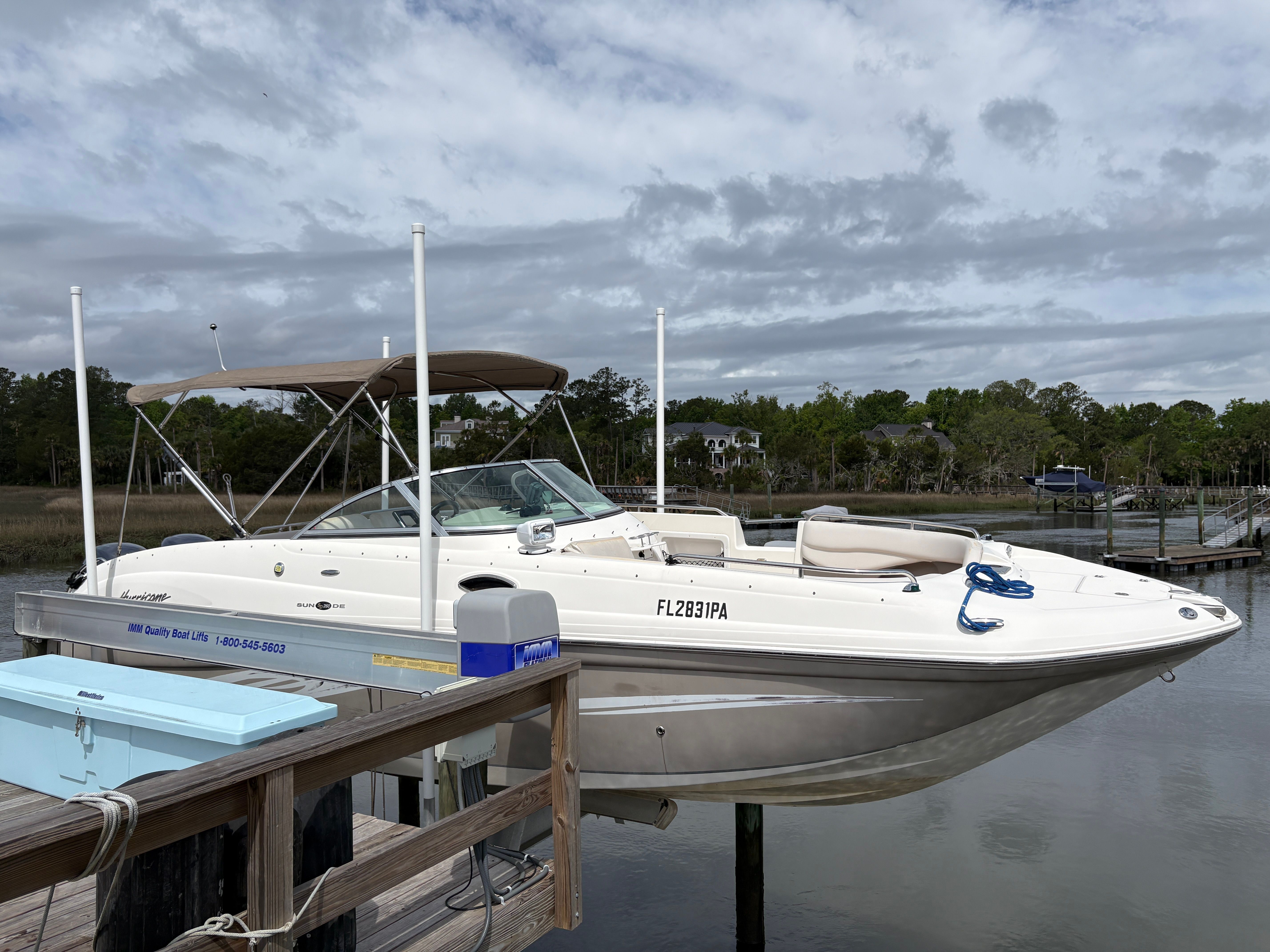 2009 Hurricane SUN DECK 260 boat docked under cloudy sky.
