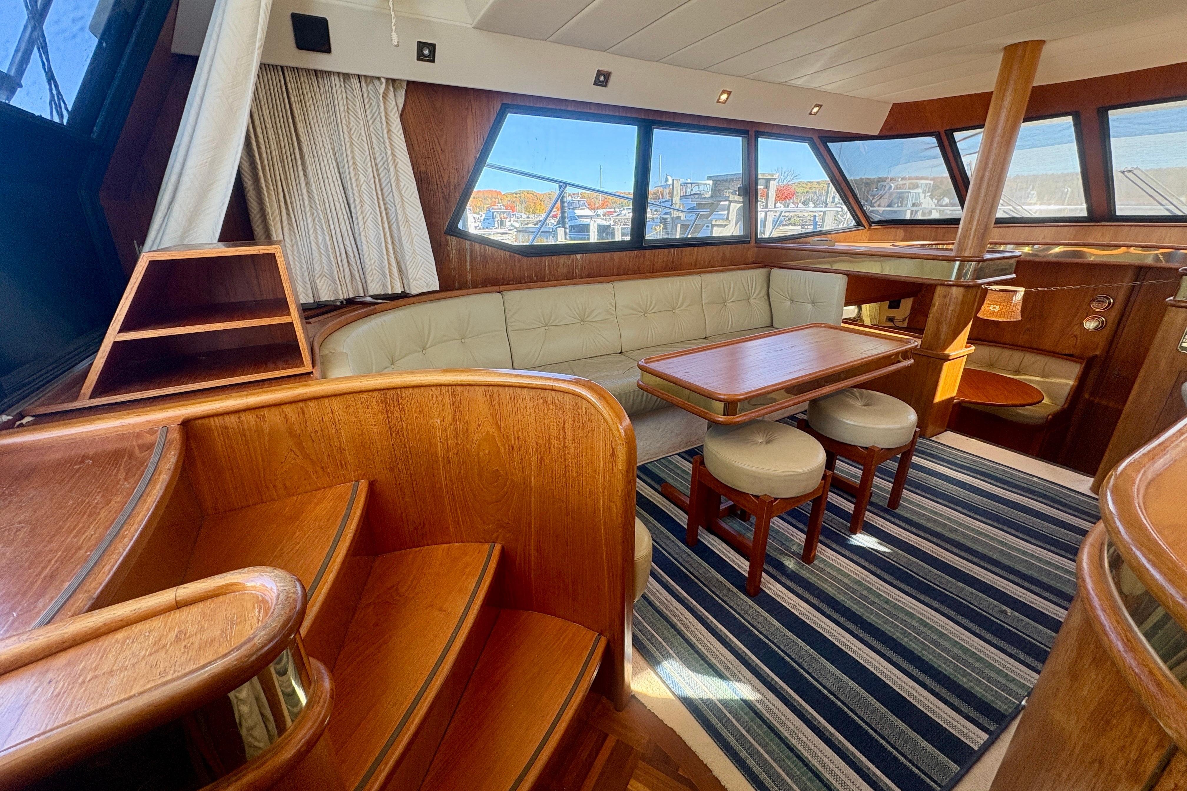 Luxurious 1990 Neptunus 145 AC yacht interior with wood accents and plush seating.