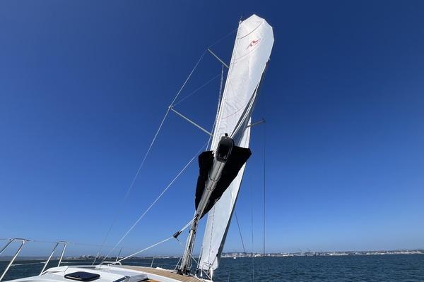 Sailing yacht Hanse 360 (2025) with sails up against clear blue sky.
