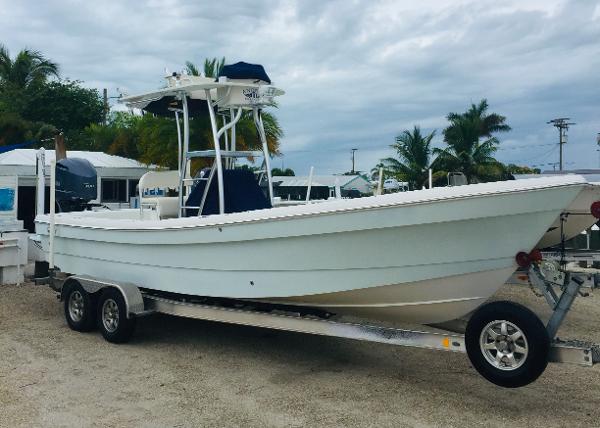 A 2011 Andros 26 Tarpon boat on a trailer, surrounded by palm trees and cloudy skies.