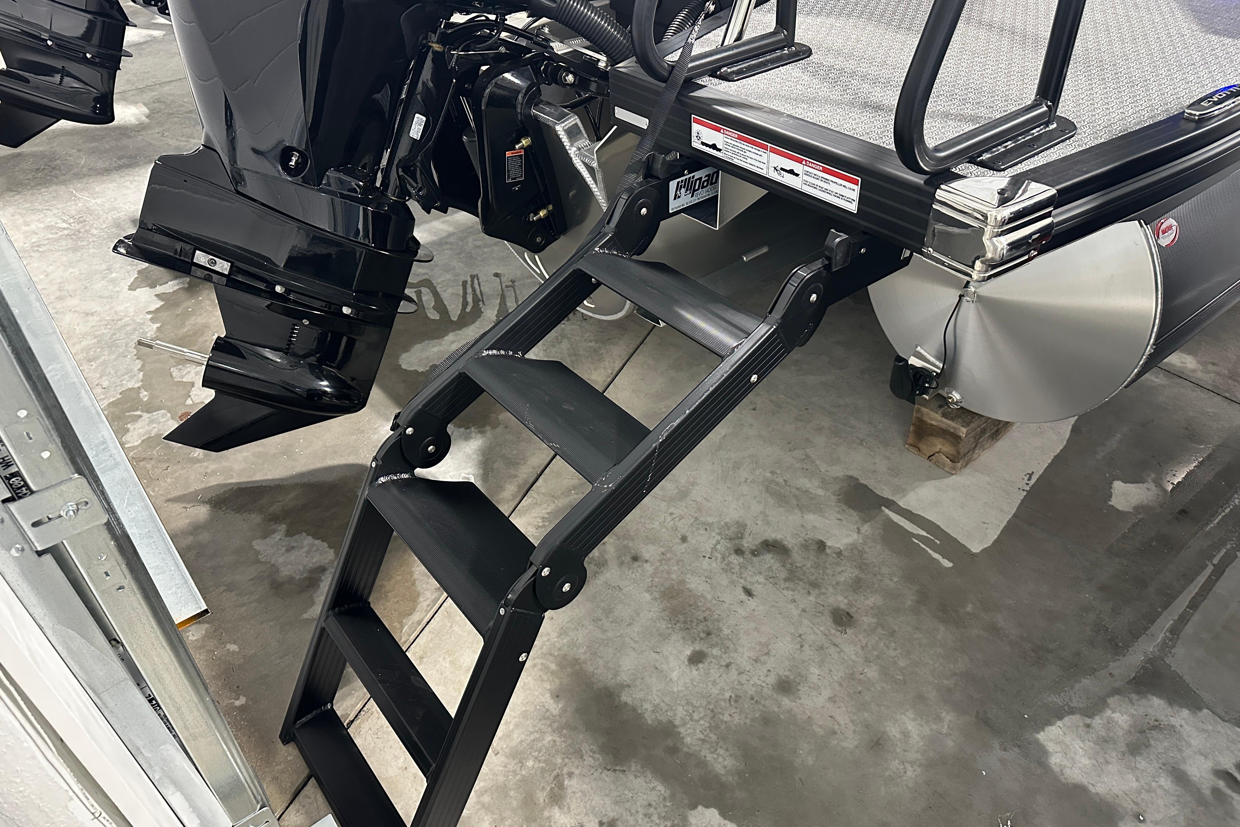 Evotti 523QL 2026 boat with ladder and motor in a garage setting.