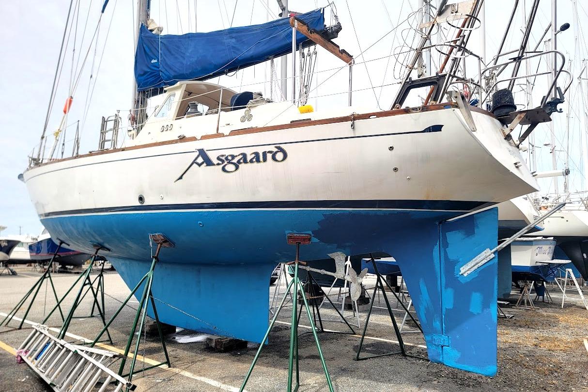 1981 CT 47 sailboat "Asgaard" on stands, blue hull, marina setting.