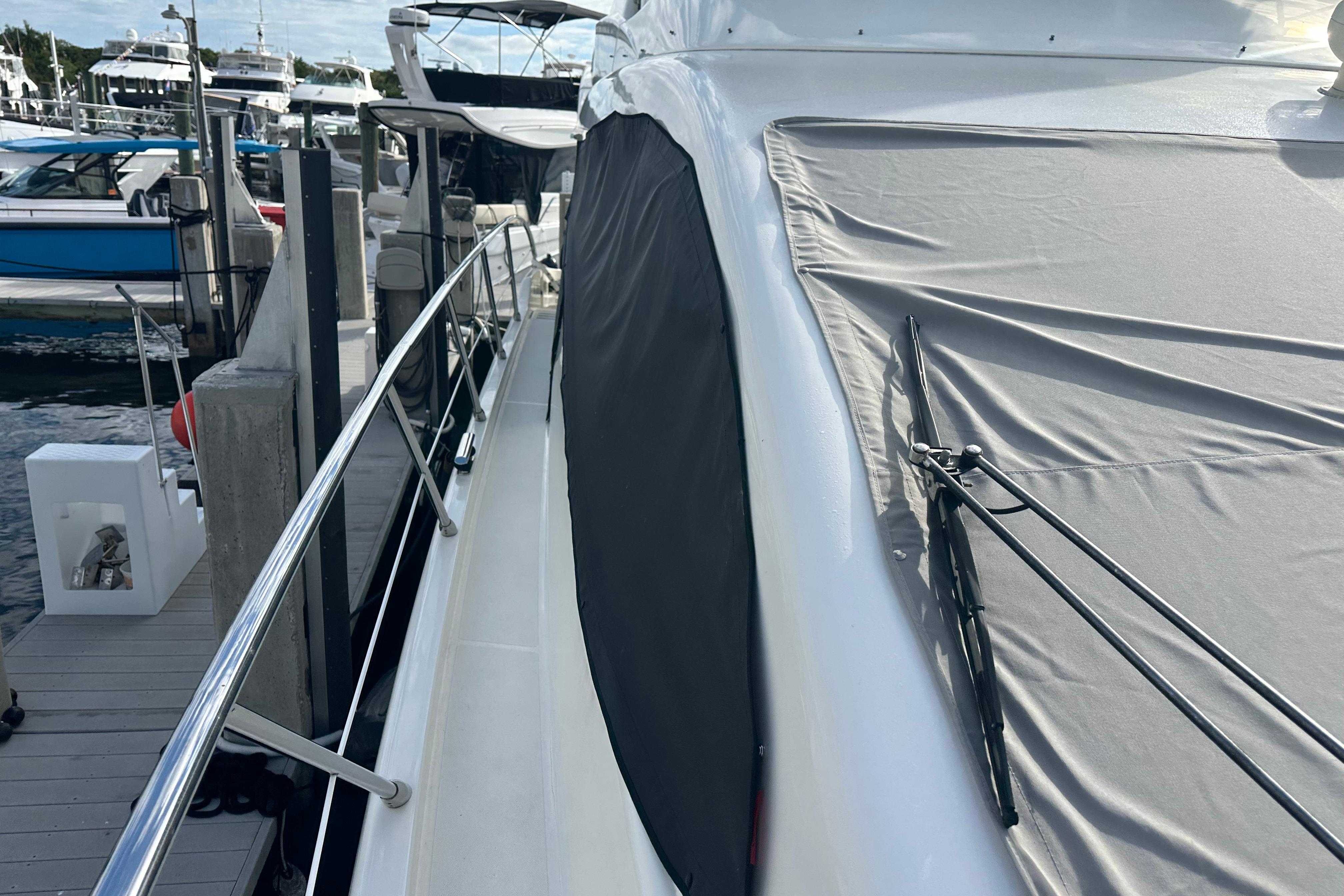 2004 Azimut 55E yacht docked, featuring covered deck and sleek railing design.