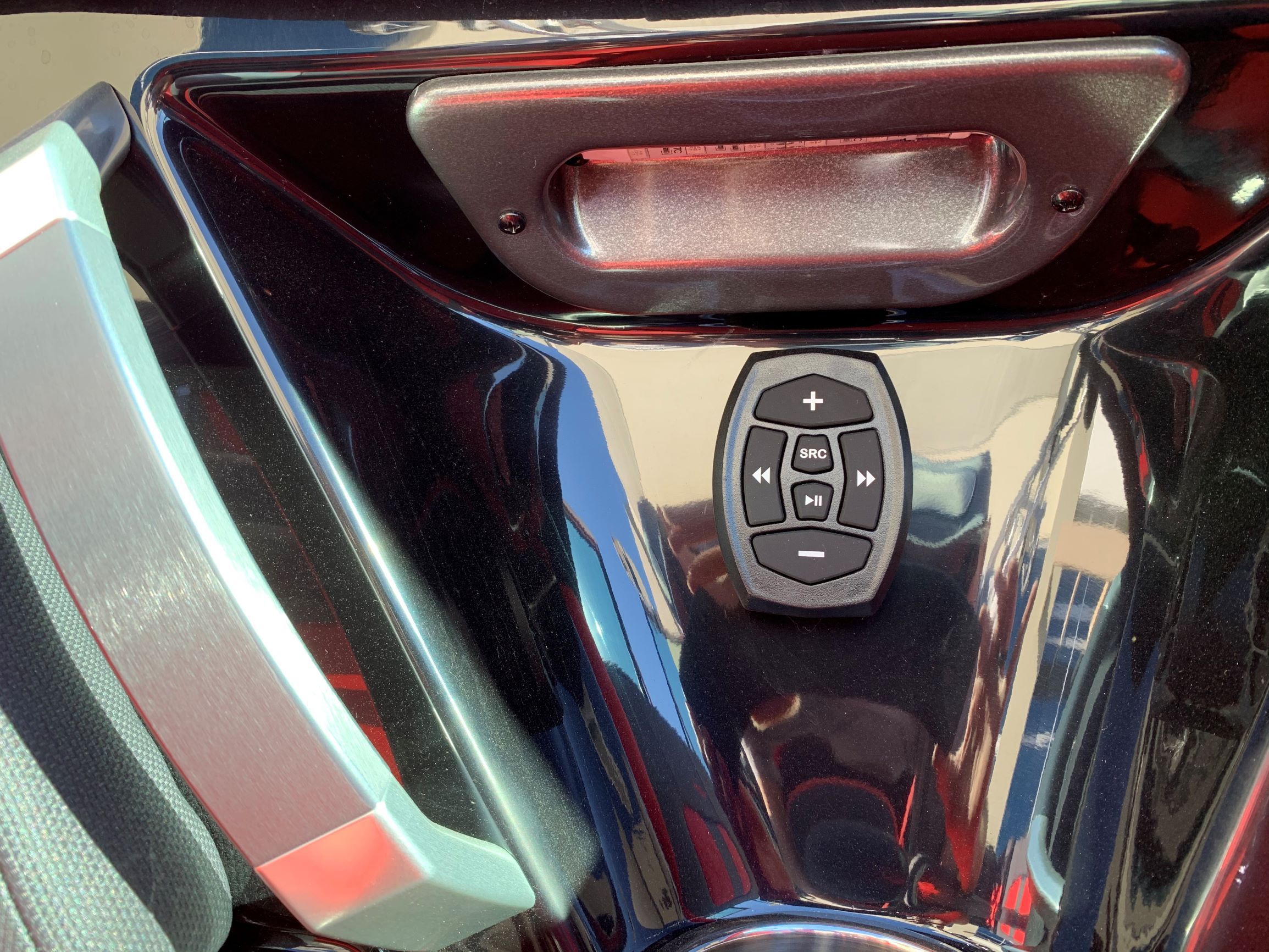Close-up of a control panel on a boat with a glossy black surface.