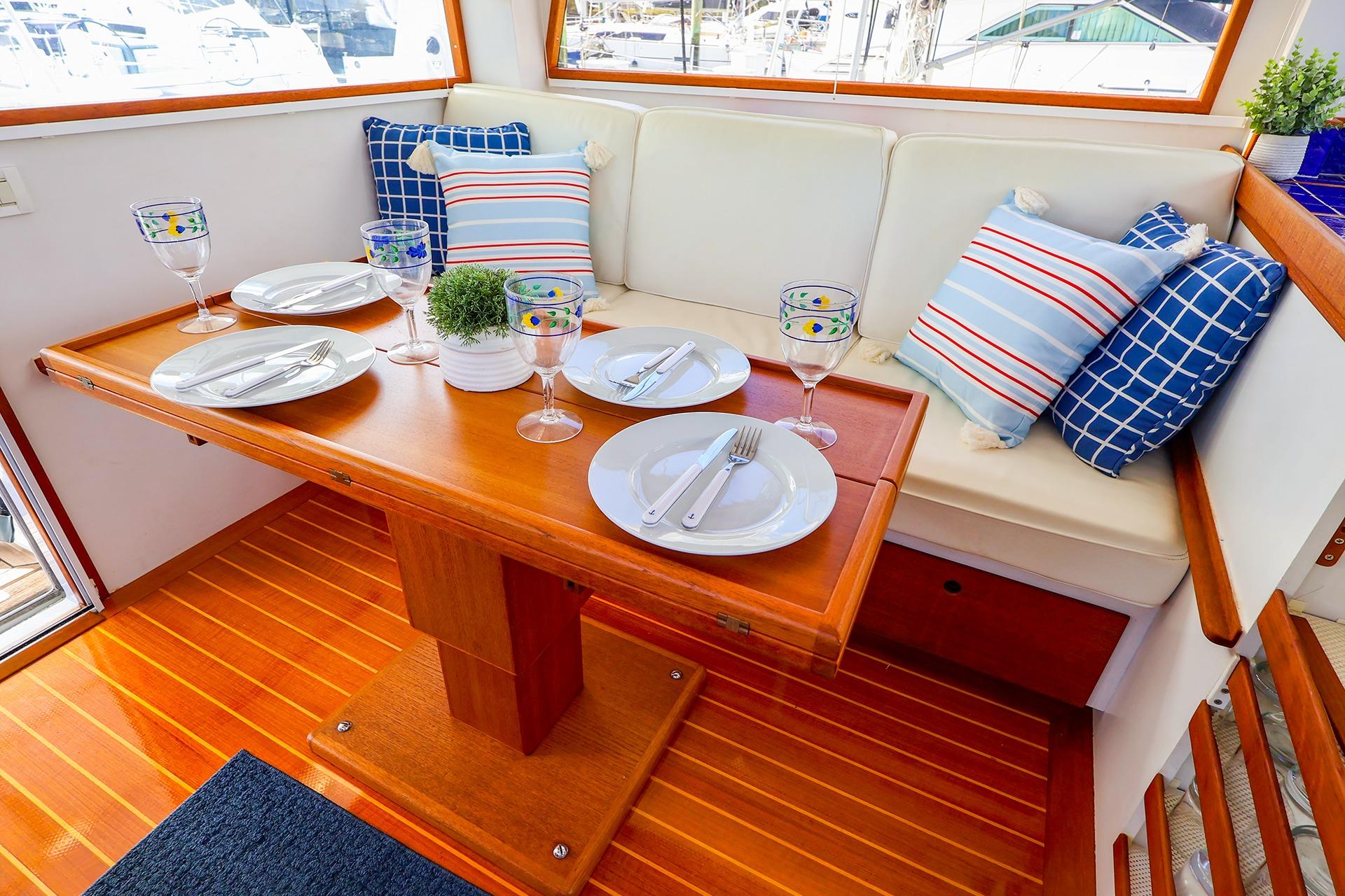 Elegant dining area on 2005 New England Boatworks Downeast Sedan, featuring nautical-themed decor.