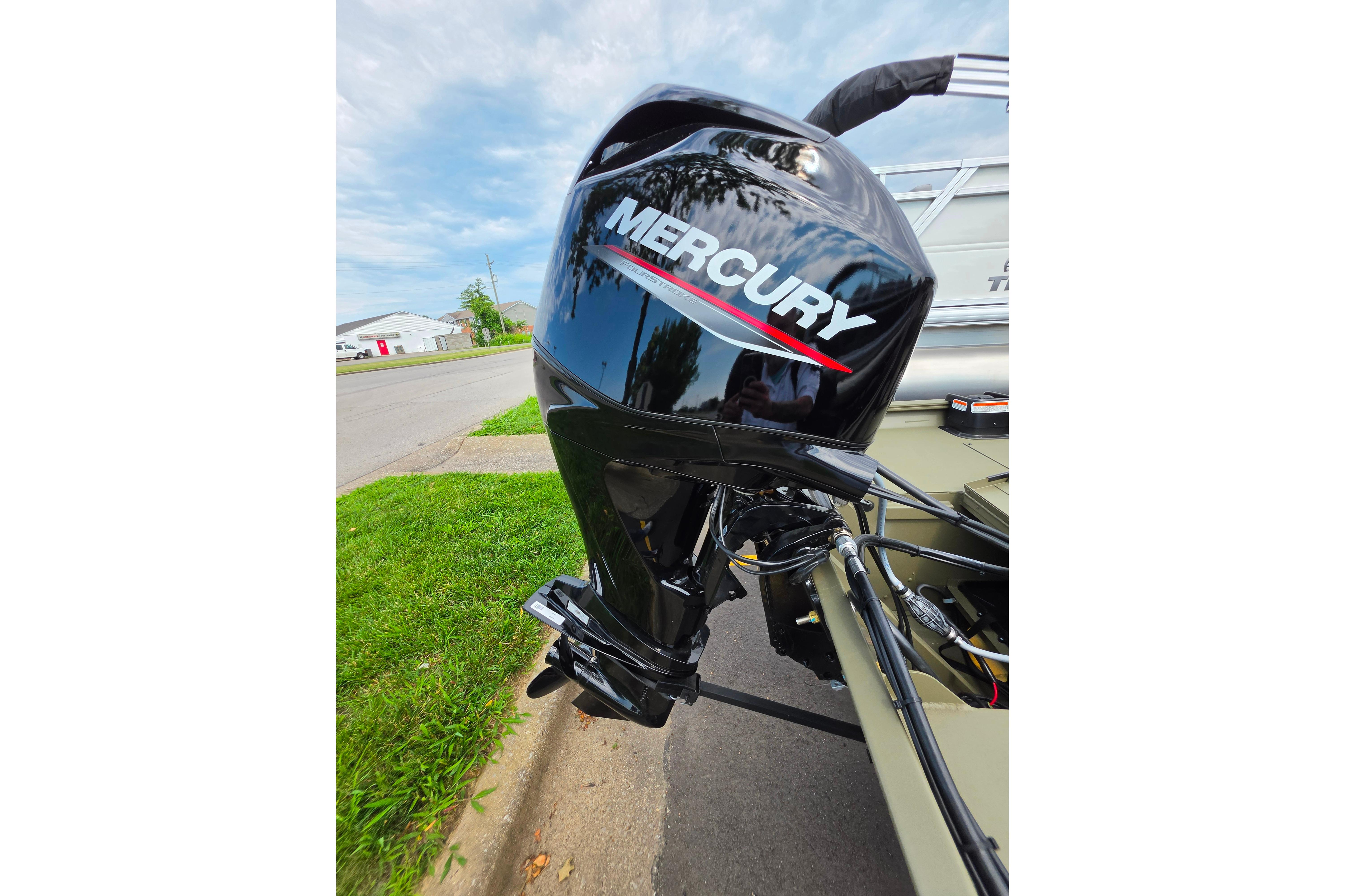 2026 Tracker Grizzly 1754 SC with Mercury outboard motor on a street.