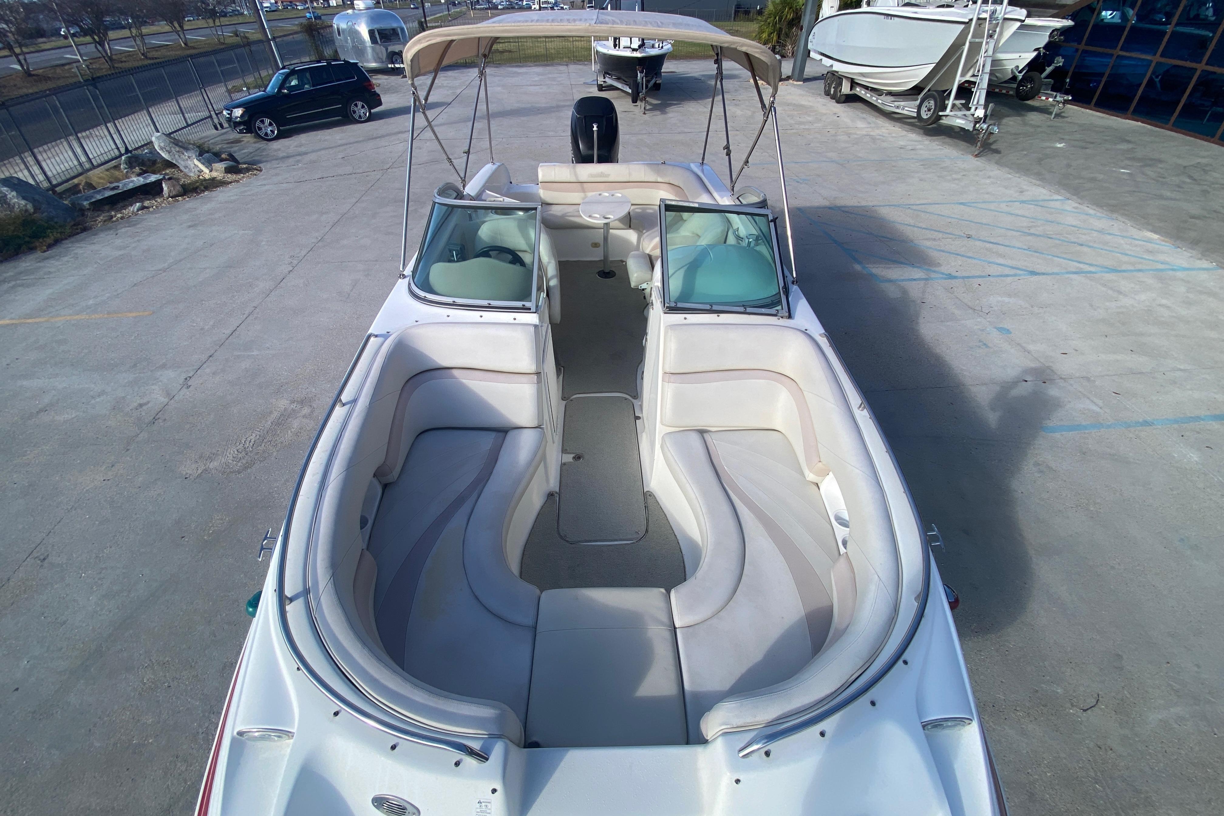 2007 NauticStar 230DC Sport Deck boat with spacious seating and canopy in a parking lot.