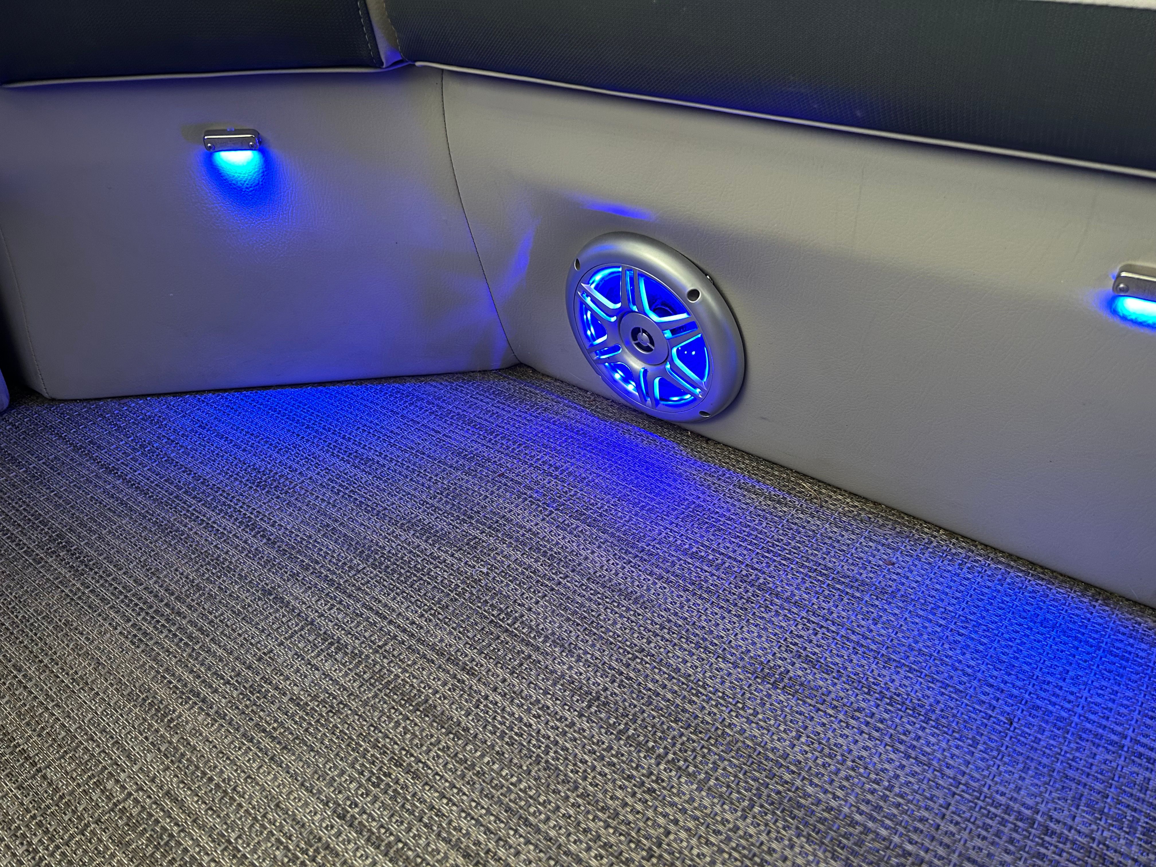 Interior of a boat with blue lighting and a speaker.