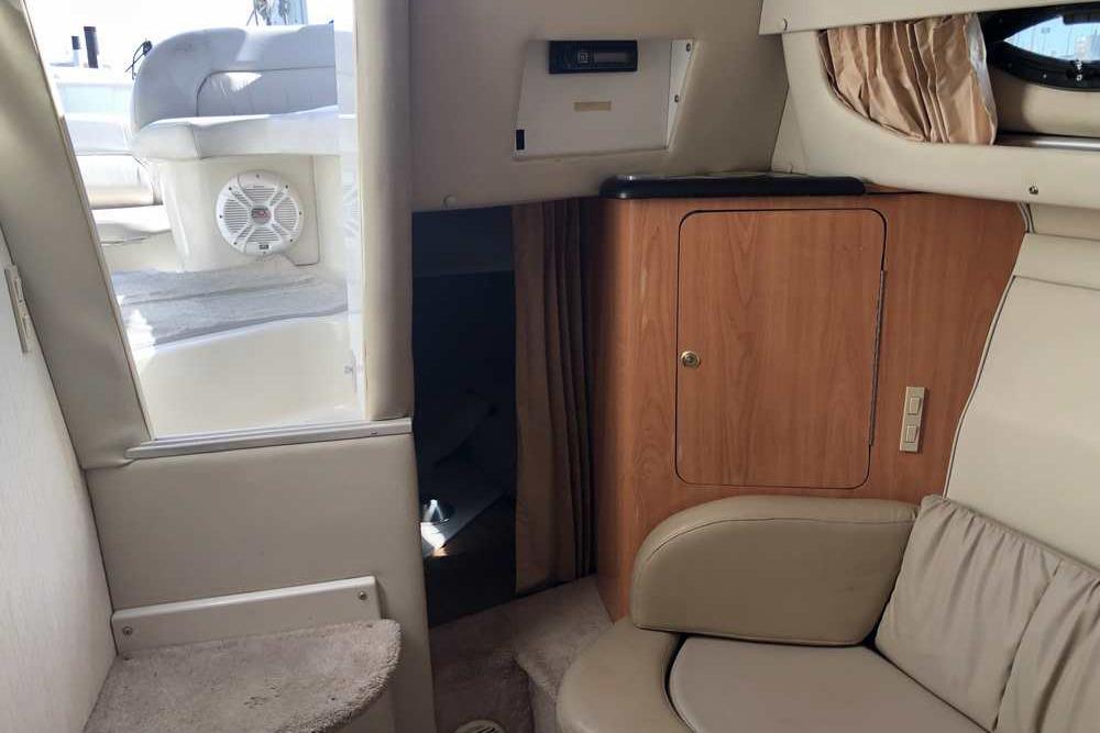 Interior of 1999 Regal Commodore 2760 boat with seating and wooden cabinetry.
