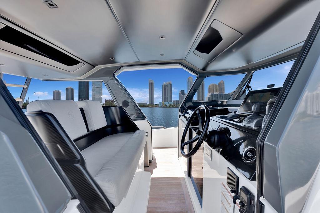 Interior of 2021 Bluegame BG 42 yacht with city skyline view through windows.