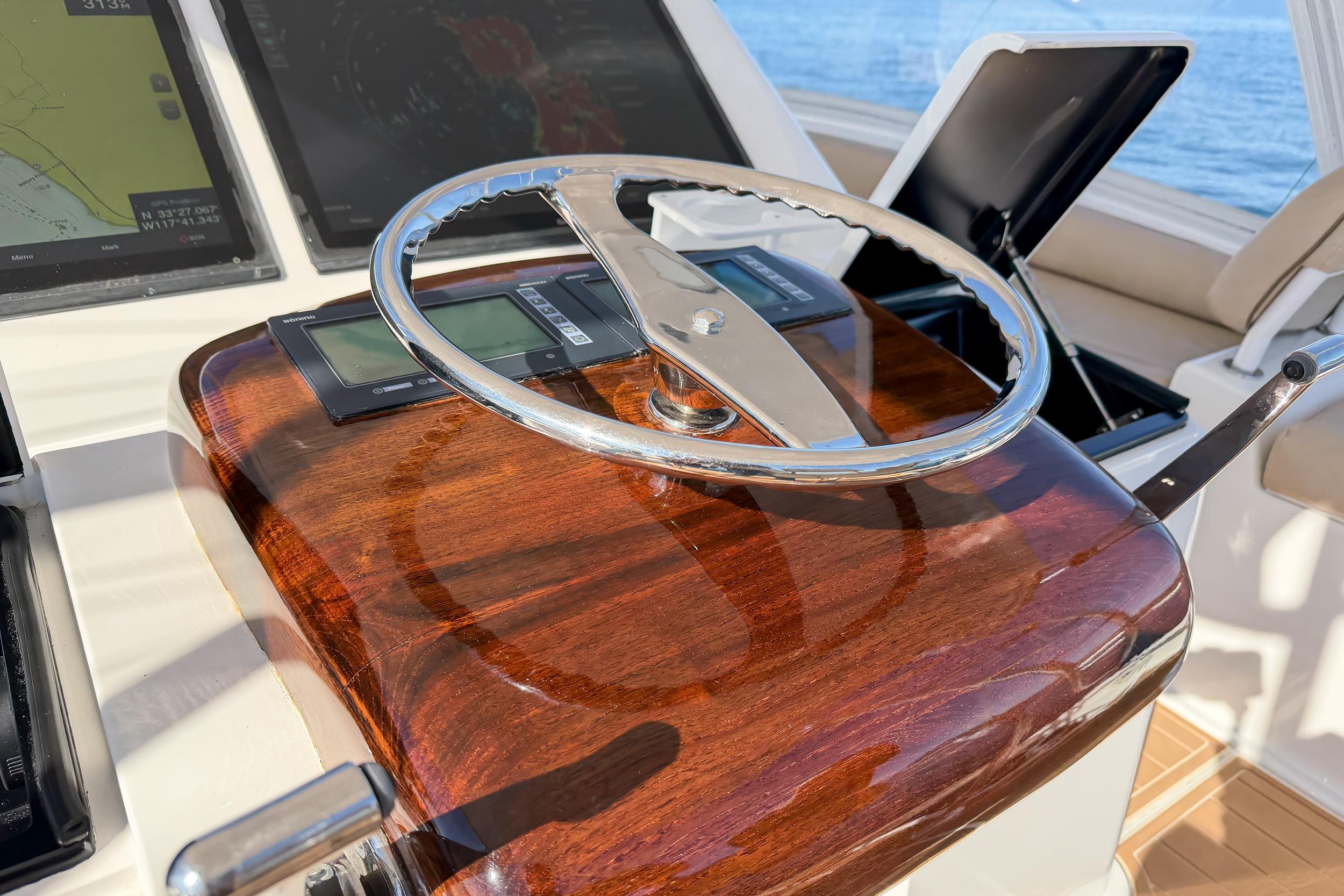 Steering wheel of 2013 Viking 46 Convertible yacht with polished wood finish.