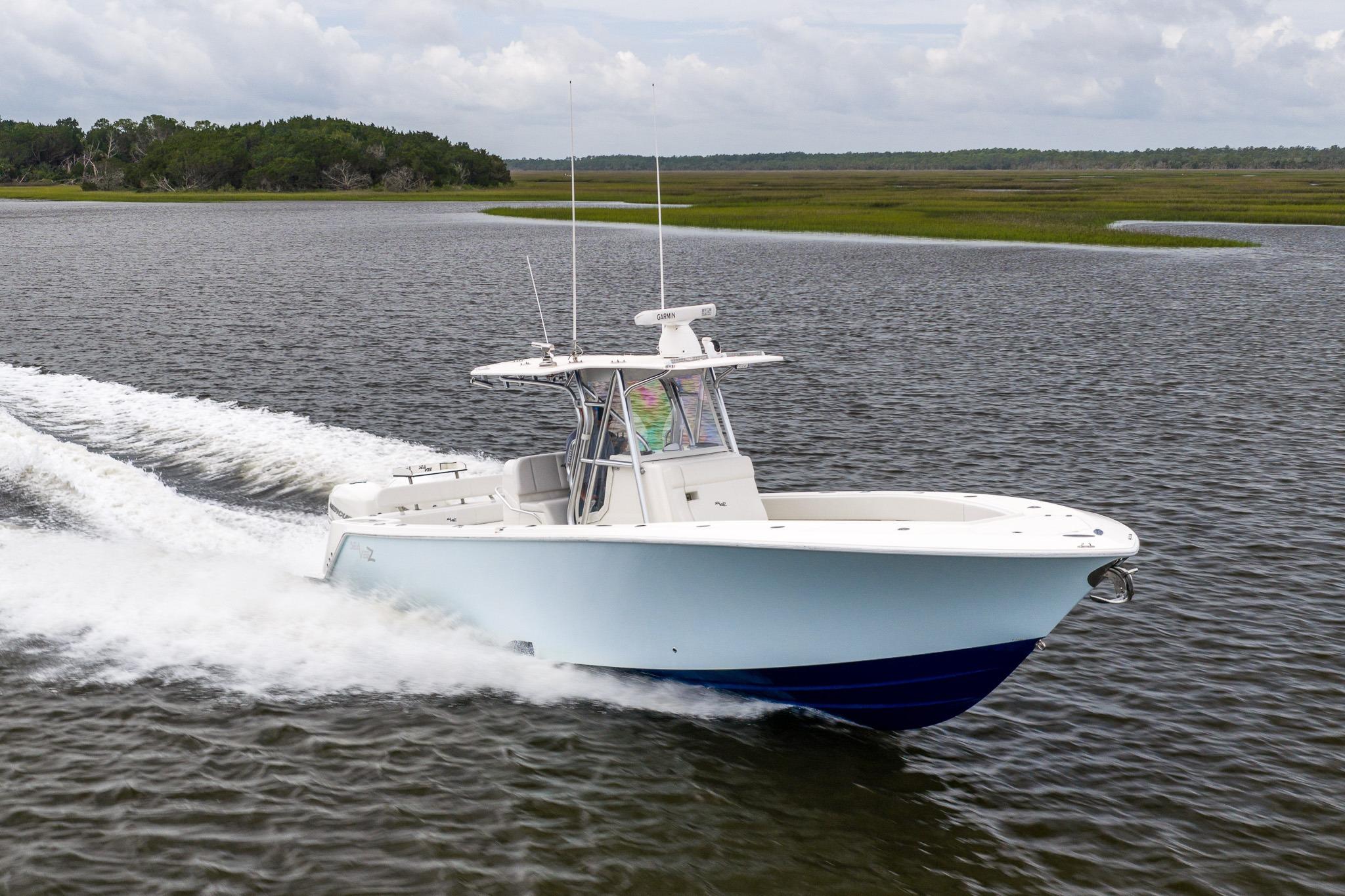 2019 SeaVee 322Z boat cruising on a scenic waterway with lush greenery.