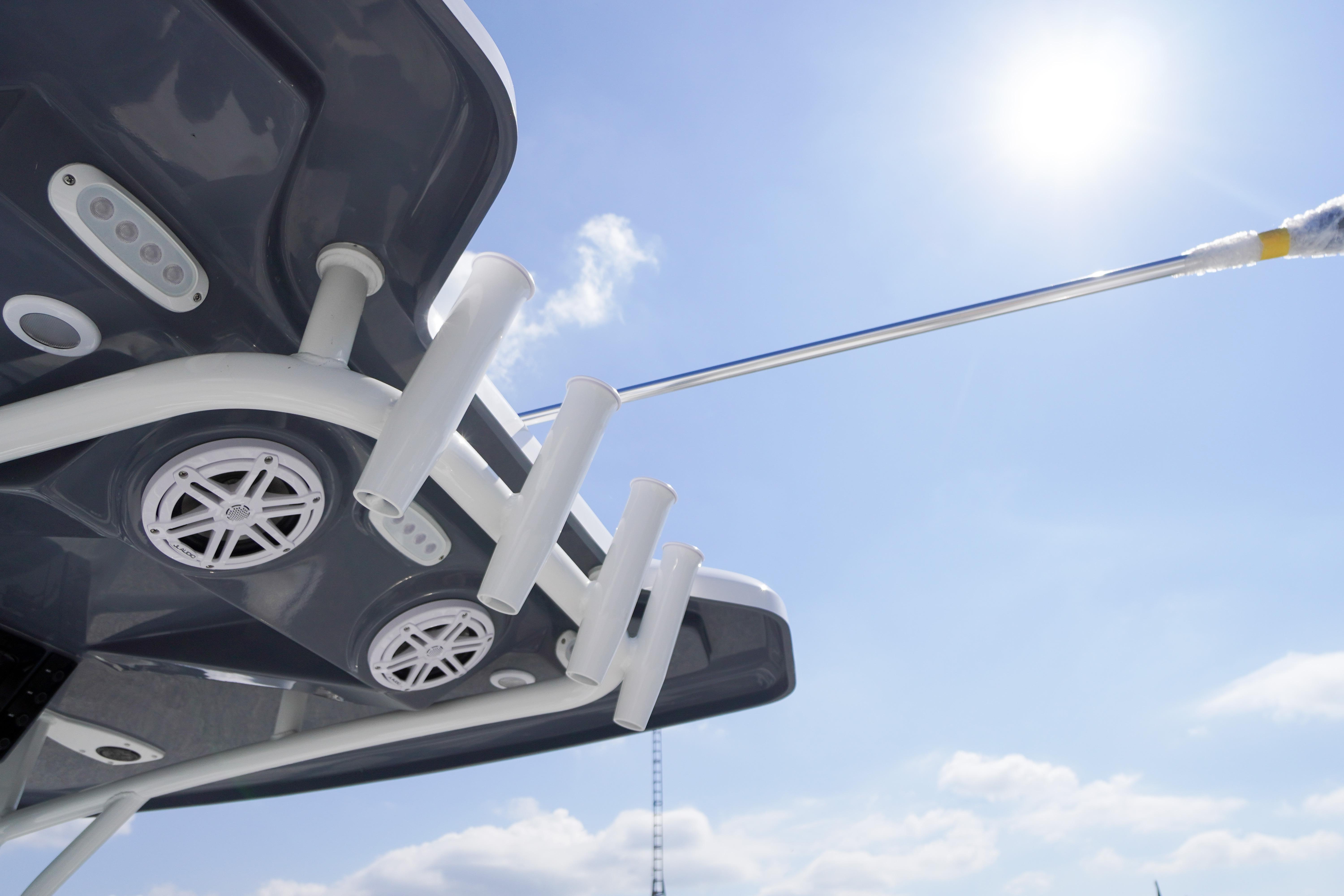 Tidewater 220 CC Adventure 2026 boat features rod holders and speakers under a sunny sky.