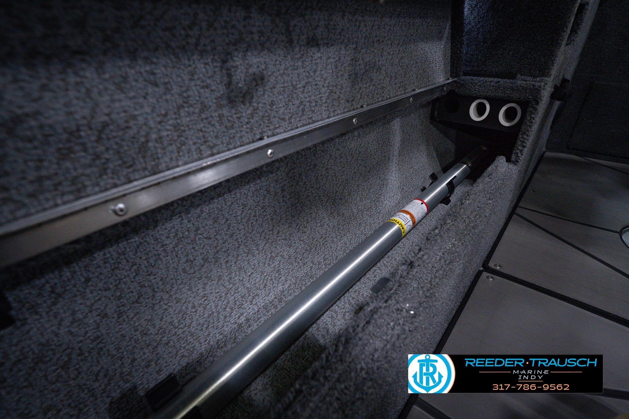 Interior storage compartment of 2026 Lund 1875 Impact XS SS boat, featuring carpeted finish.